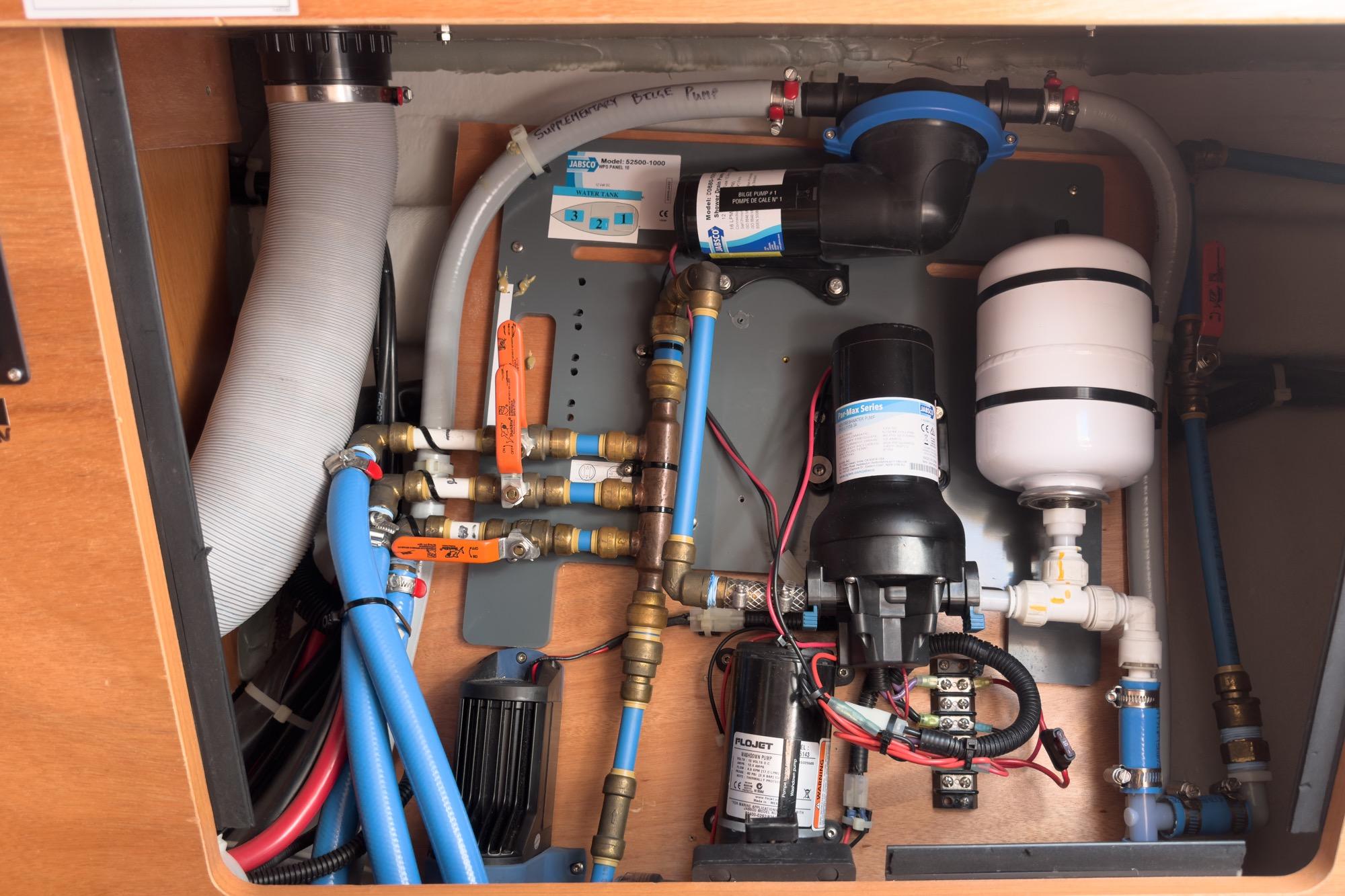 Plumbing system inside a 2017 Beneteau Sense 50 yacht, featuring pipes and fittings.