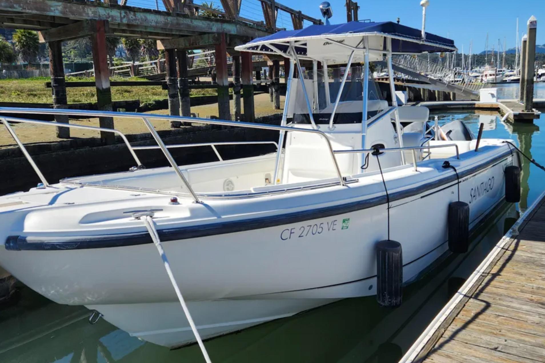 2001 Boston Whaler 26 Outrage boat docked at marina under clear blue sky.