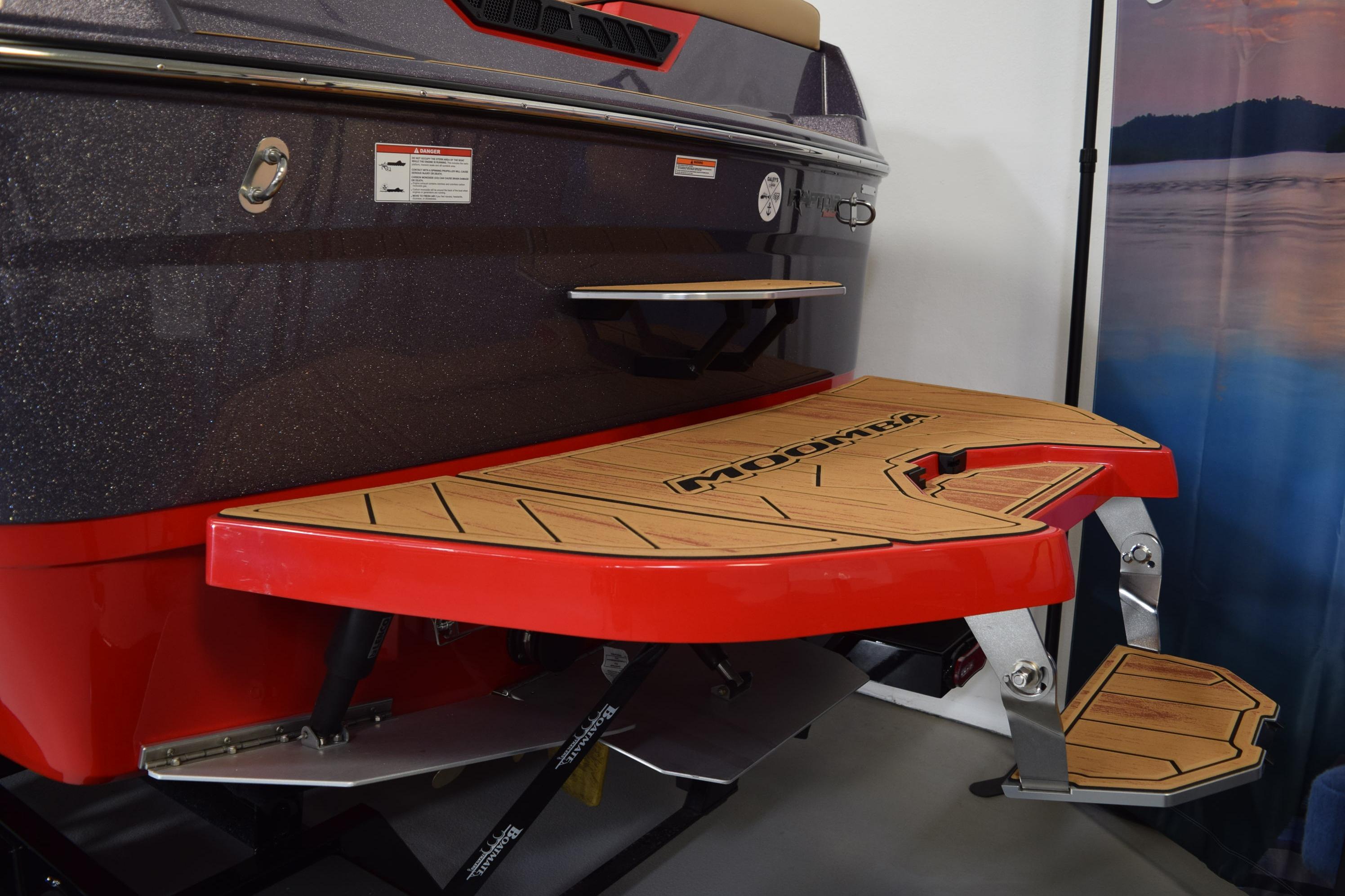 2026 Moomba Max boat with red swim platform and teak accents.
