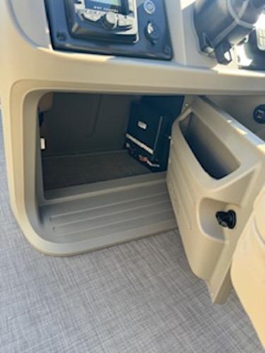 Interior of 2025 Sun Tracker Fishin' Barge 22 DLX with storage compartment.