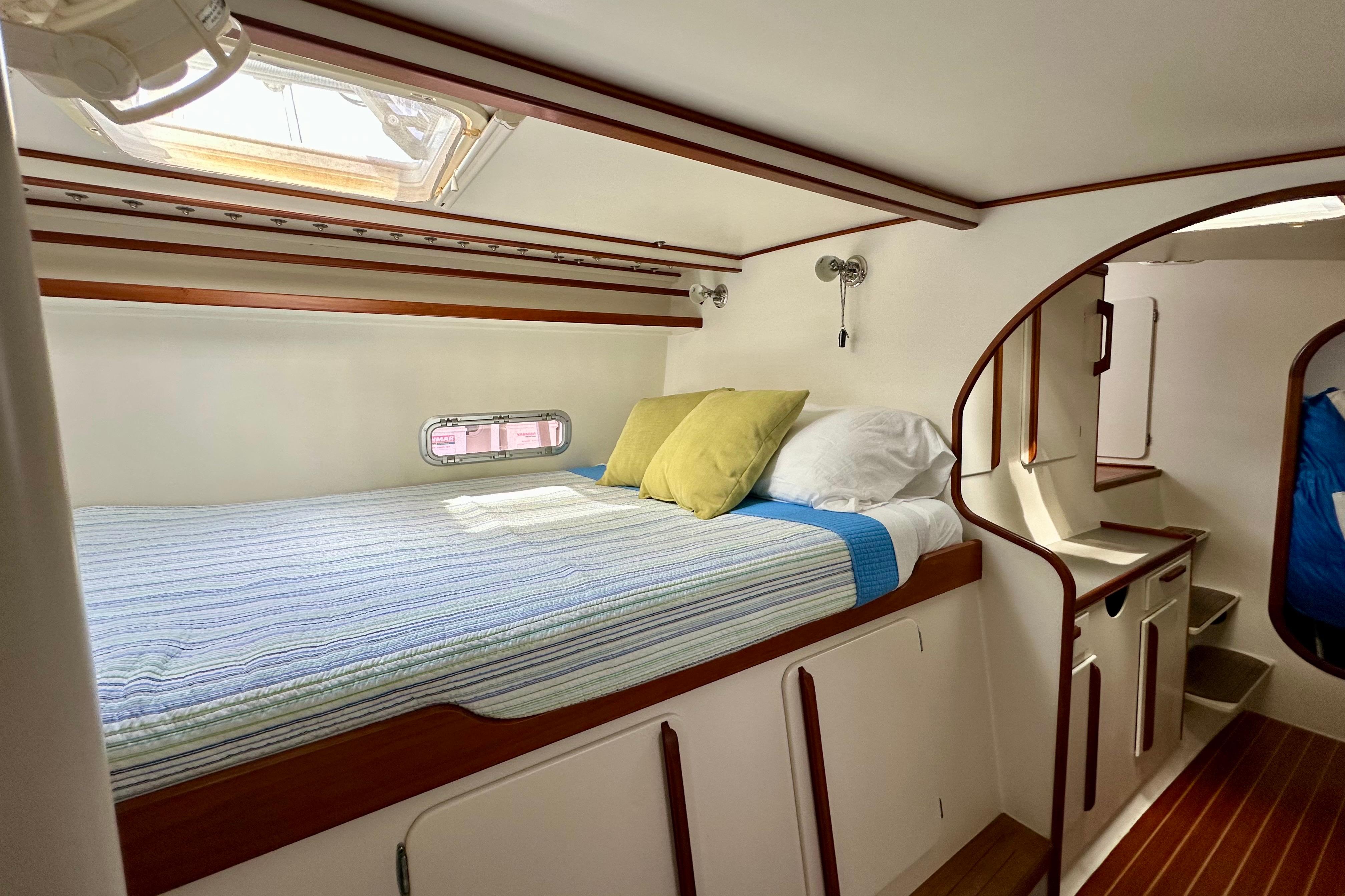 Cozy cabin interior of 2003 Chris White Atlantic 42 catamaran with bed and porthole.