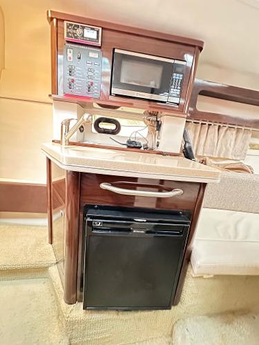 2015 Sea Ray 260 Sundancer interior kitchenette with microwave and mini-fridge.