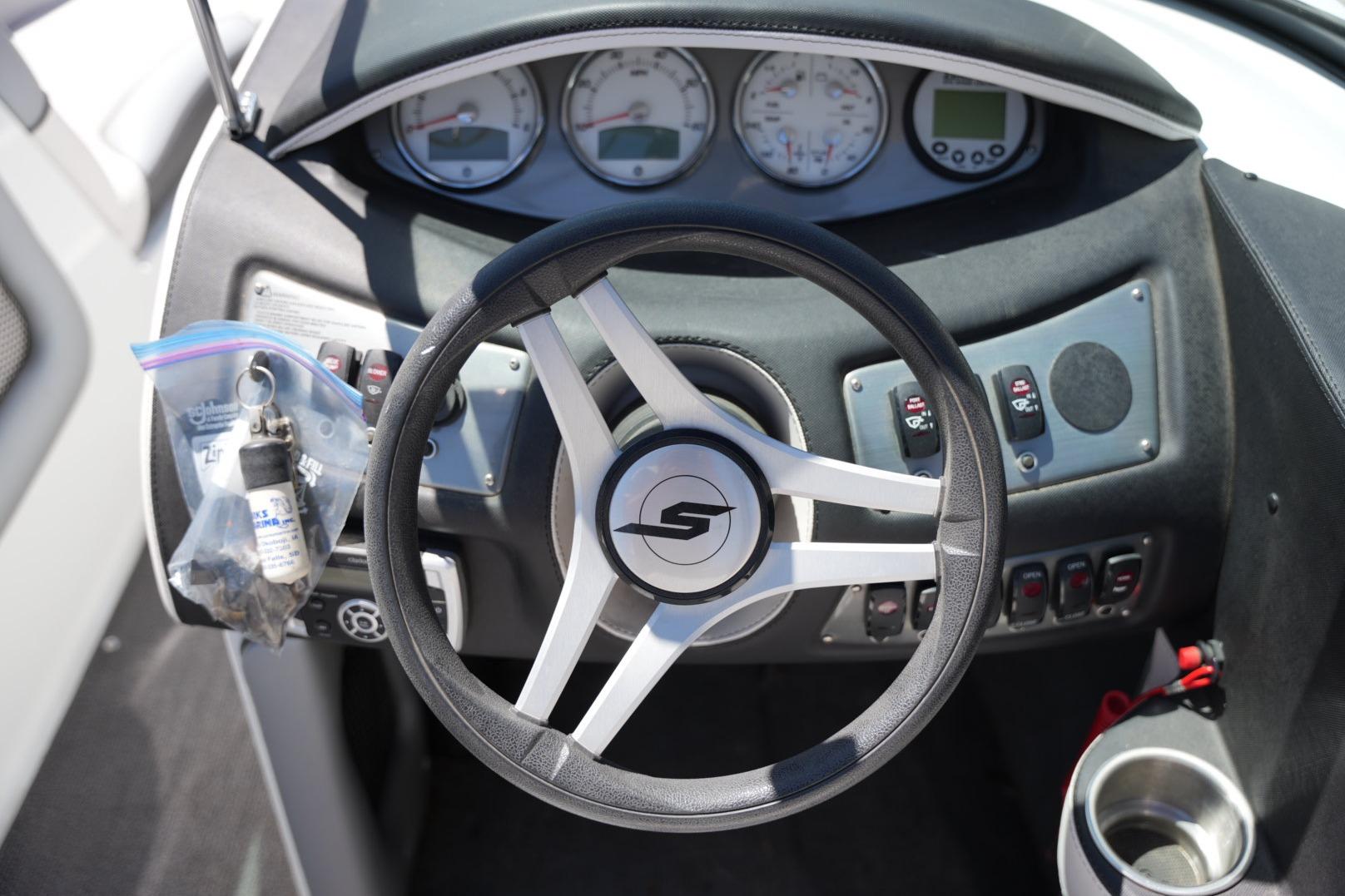 Steering wheel of a 2016 Supreme S211 boat with dashboard controls and gauges.