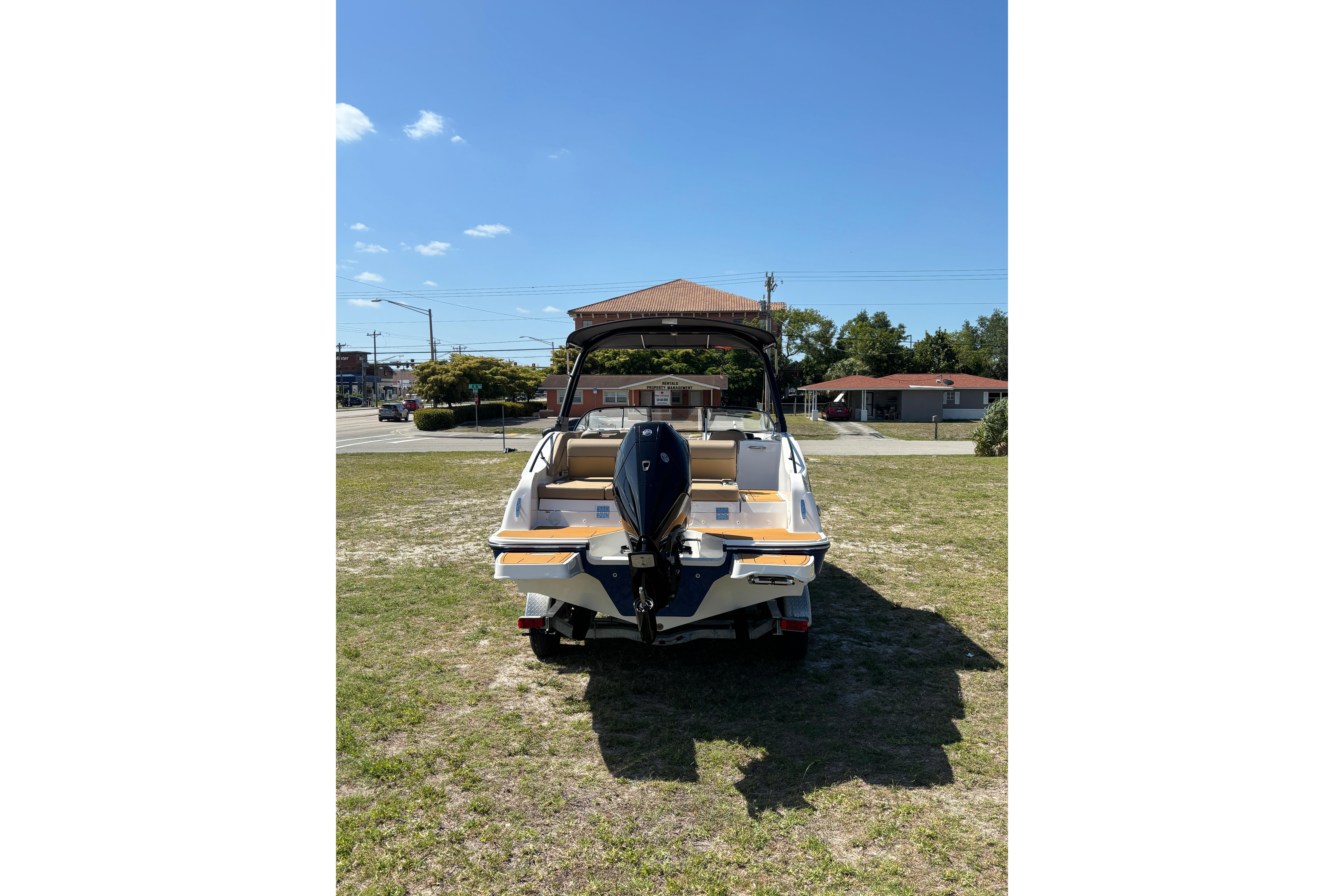 2026 Bayliner D22 boat on grass, rear view with outboard motor.