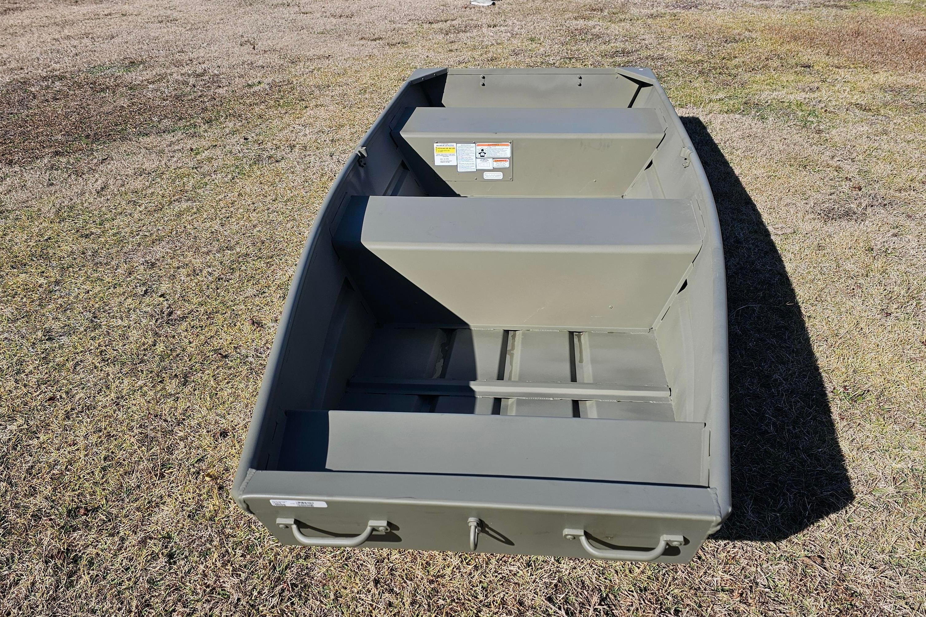 2026 Tracker Grizzly 12 Jon boat on grass, showcasing interior seating and storage.