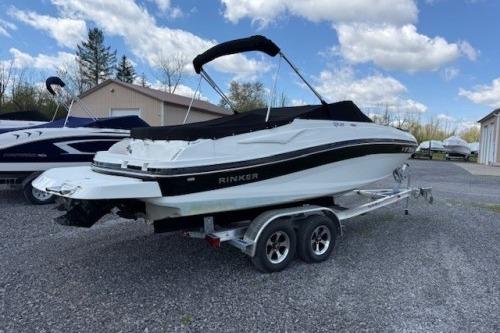 2017 Rinker QX21 BR boat on trailer, parked outdoors under a cloudy sky.