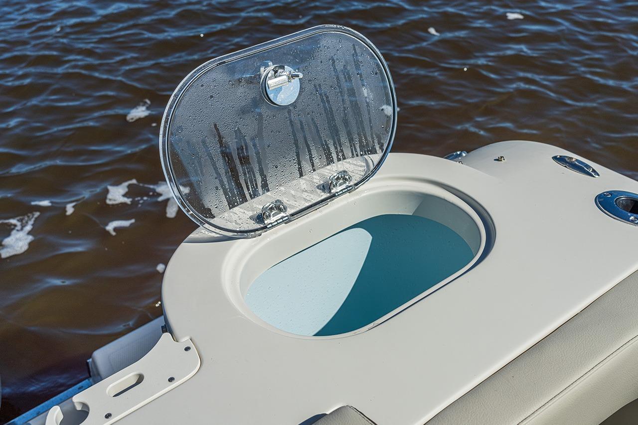 Open livewell on 2026 Sailfish 245 DC boat, with water in the background.