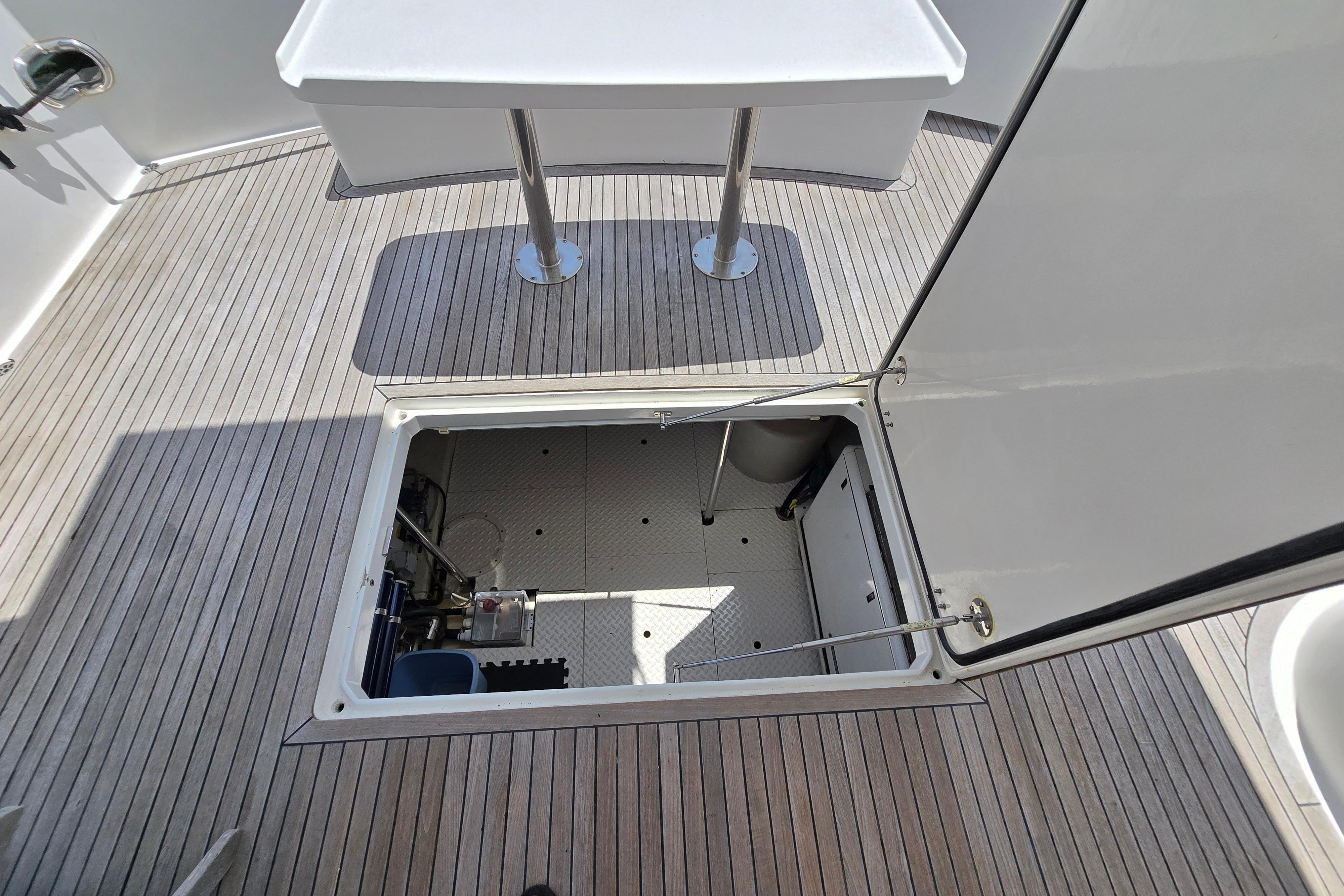 Open hatch on 2004 Grand Harbour 58 yacht deck, revealing storage compartment.