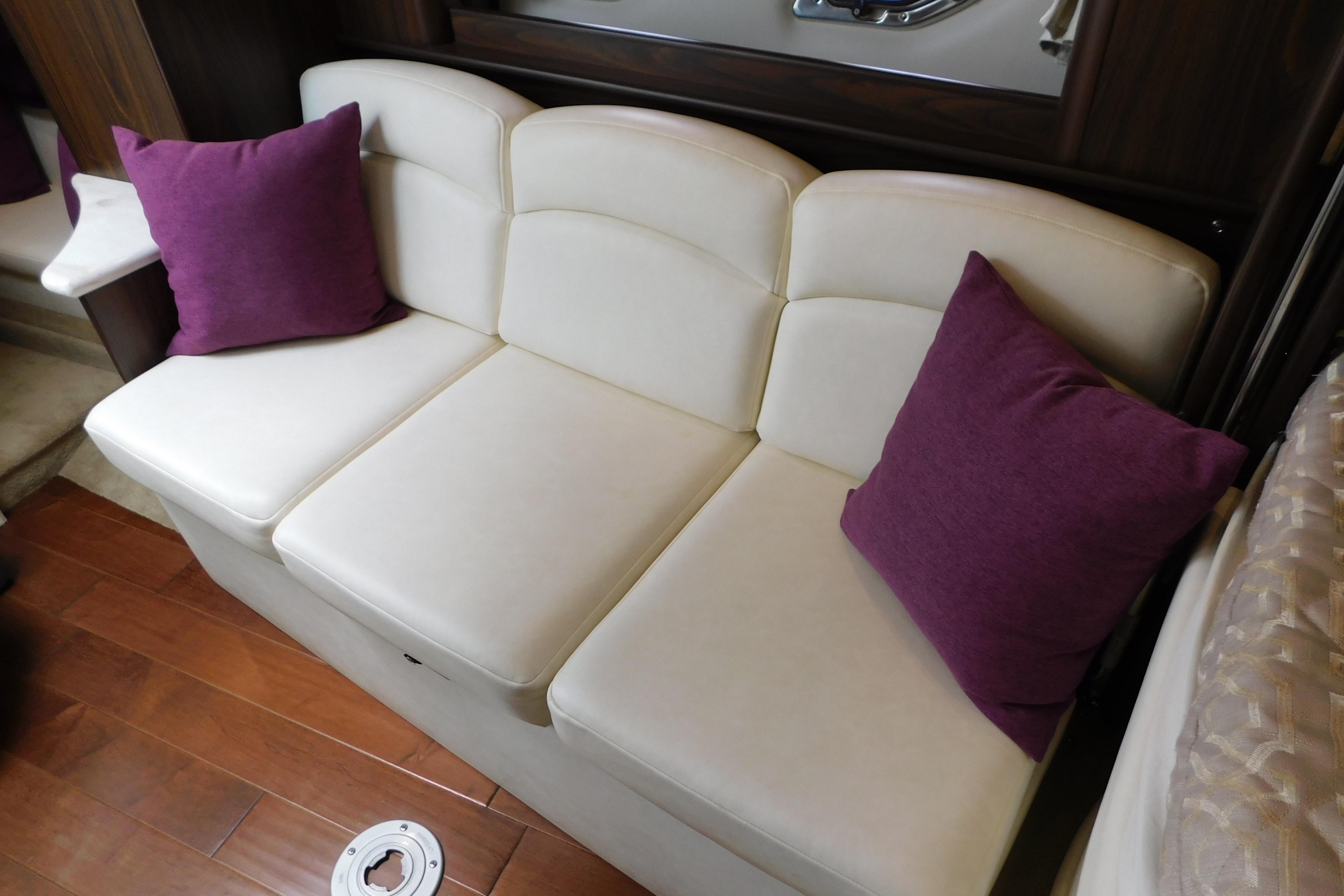 Cream sofa with purple cushions in 2017 Rinker EX 320 boat interior.