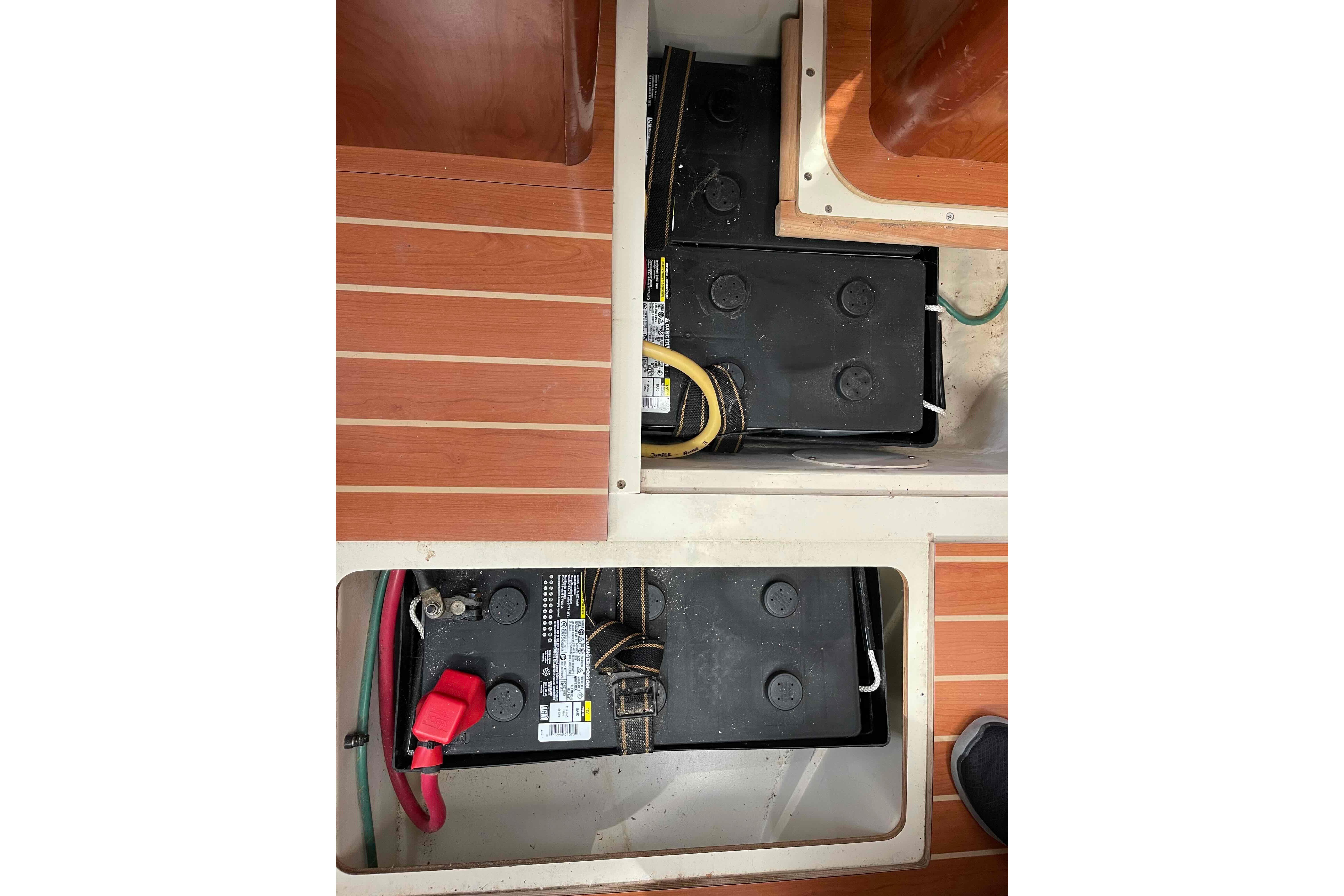 Battery compartment of 2010 Hunter 45 Center Cockpit sailboat with wooden flooring.