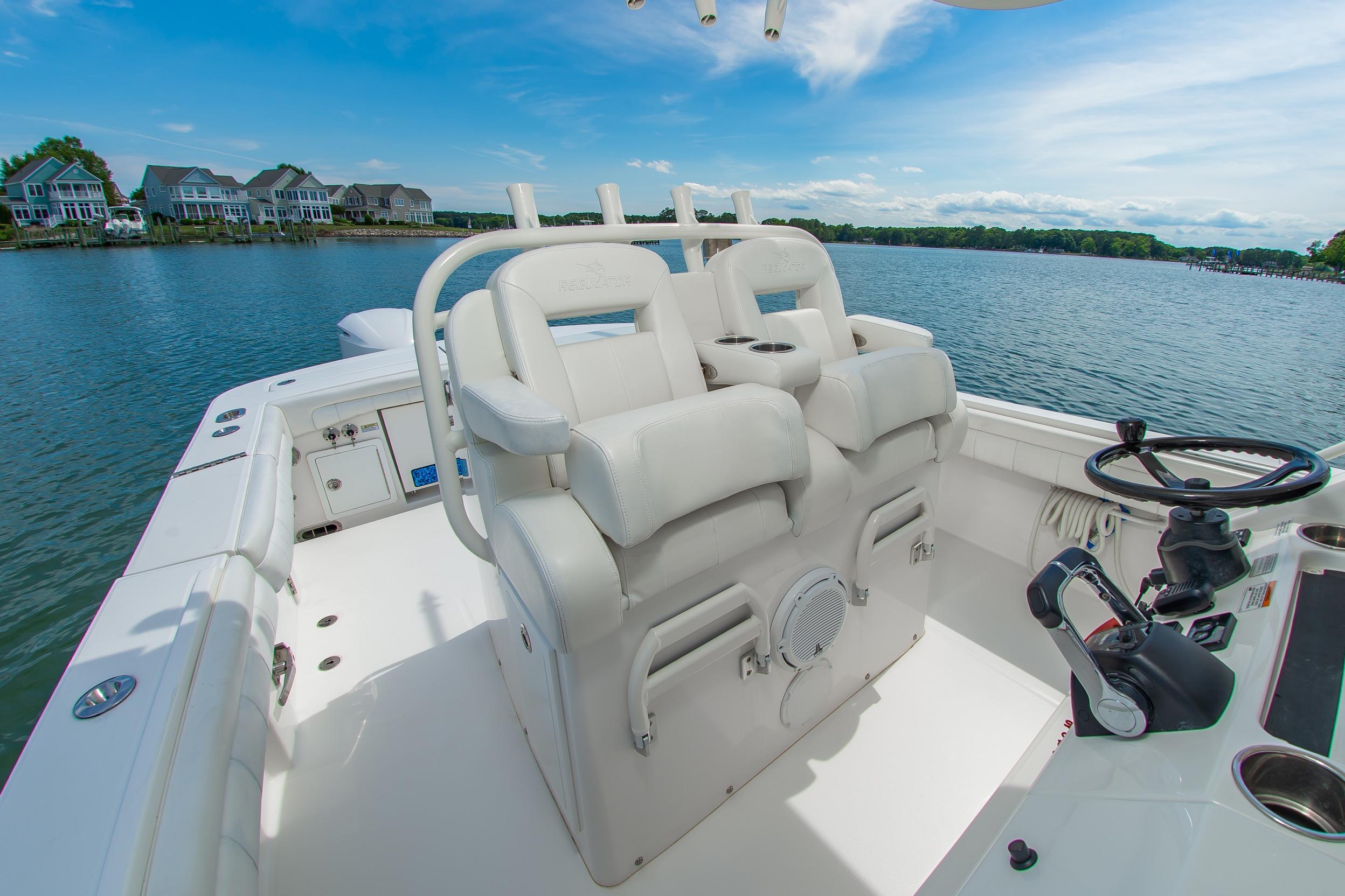 2019 Regulator 31 boat interior with helm, white seating, and scenic waterfront view.