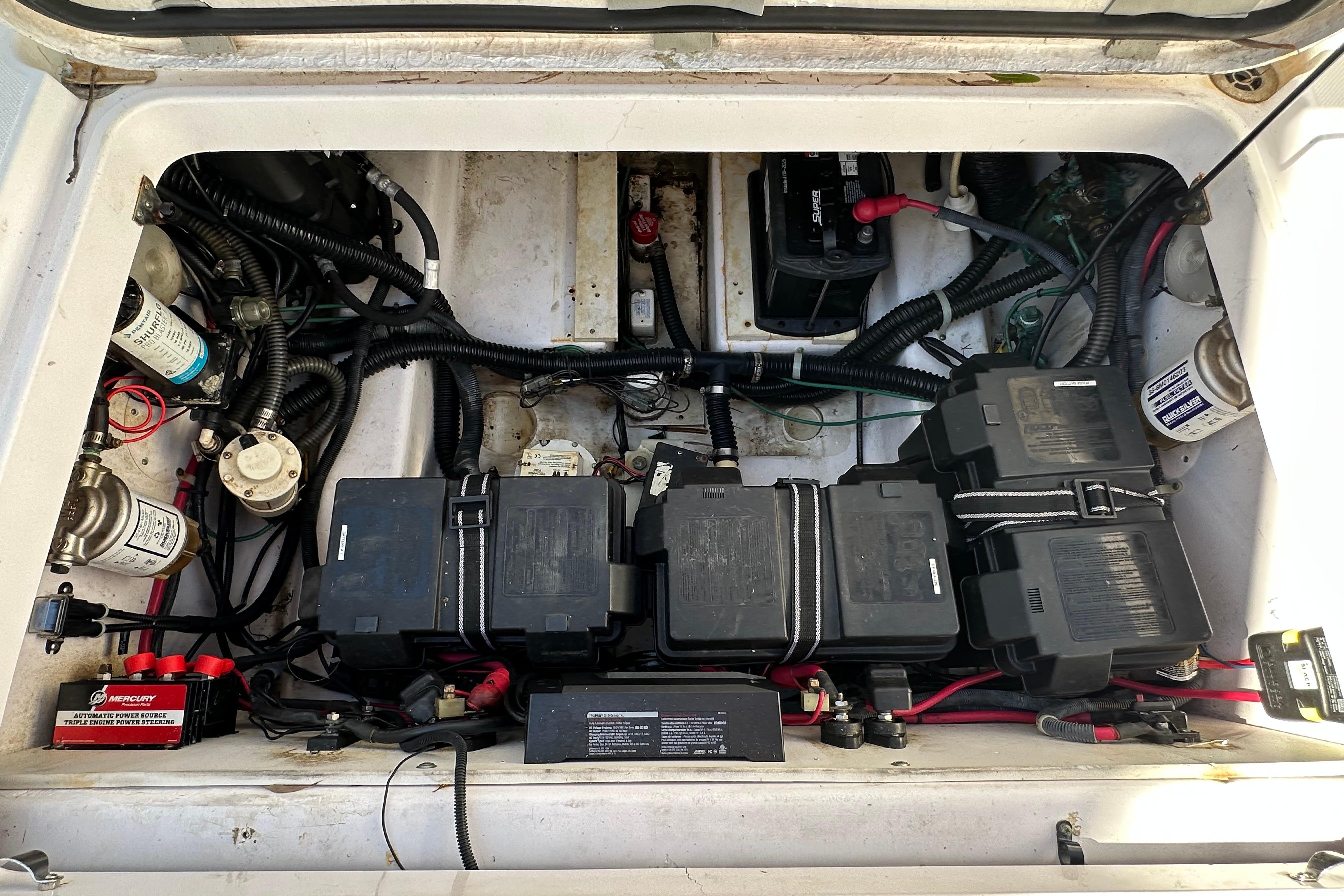 Engine compartment of a 2006 Pro-Line 32 Express boat with batteries and wiring.