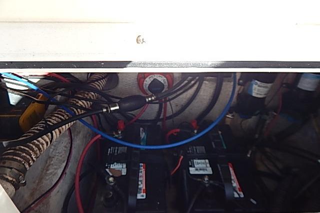 Engine compartment of 2003 World Cat 270 EC with visible wiring and batteries.