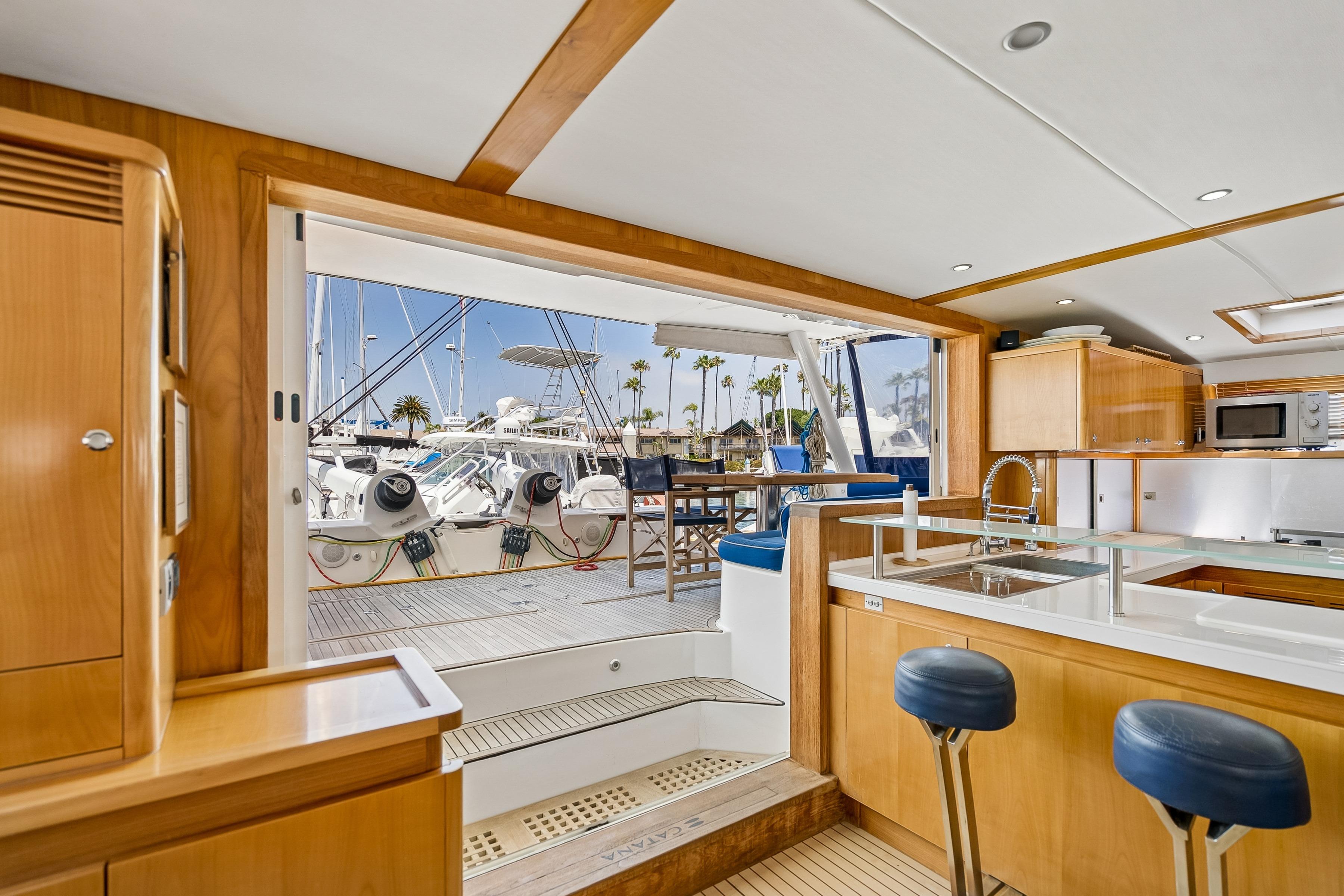 Luxurious interior of 2009 Catana 65 yacht with modern kitchen and marina view.
