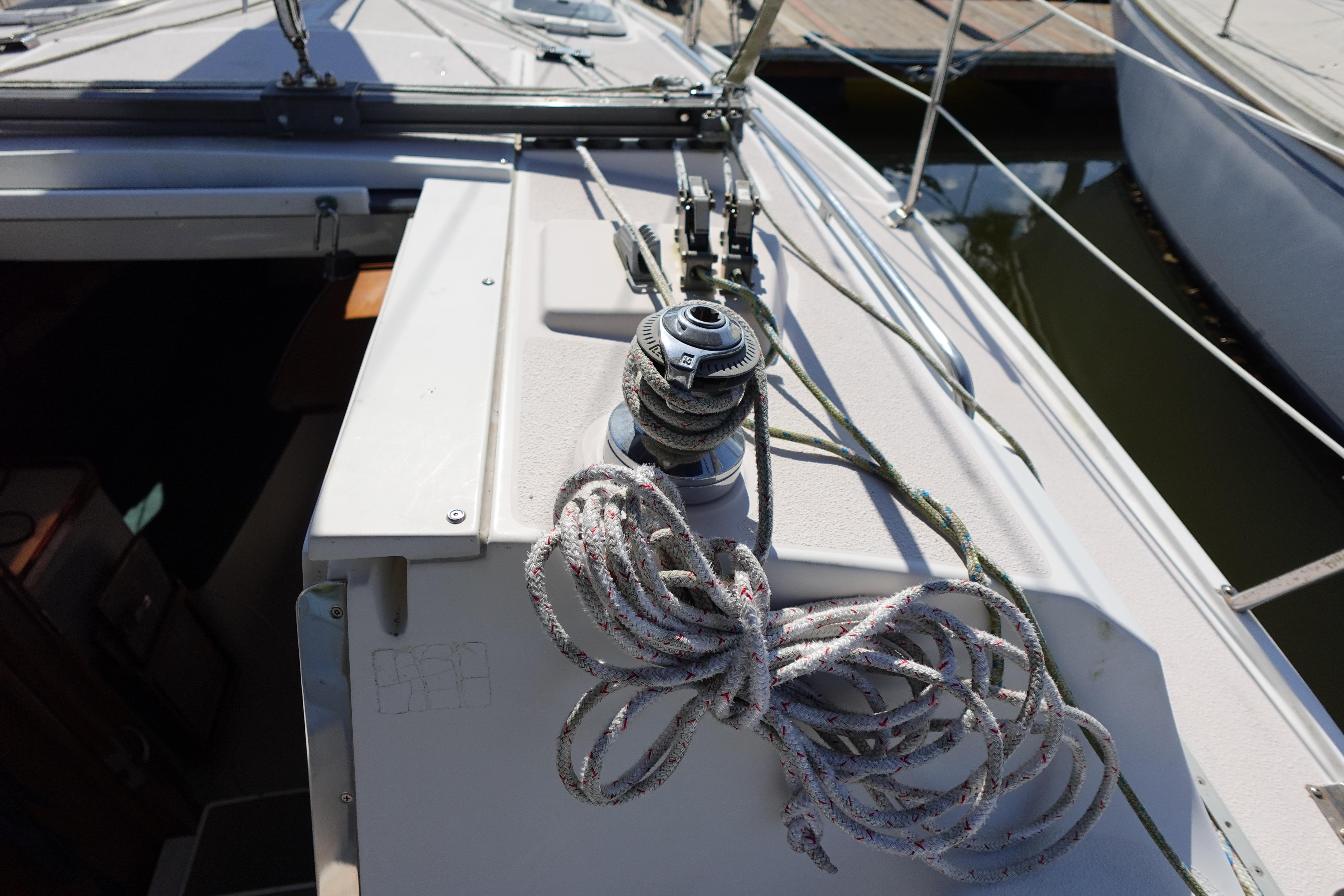 Sailboat deck of 1997 Catalina 28 with winch and coiled rope.