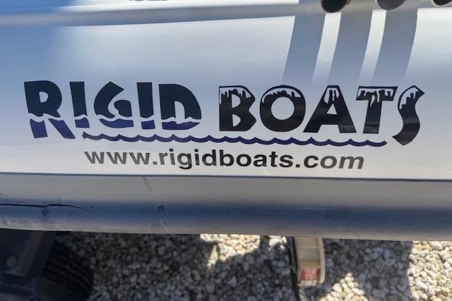 Rigid Boats 10 Sport 2024 logo with website URL on boat exterior.