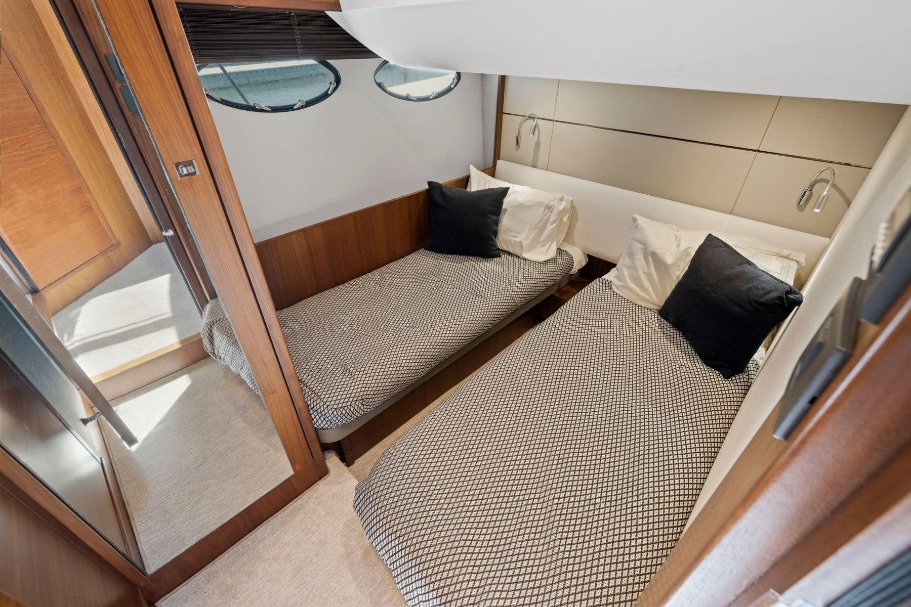 Twin cabin interior of 2015 Princess 60 Flybridge Motor Yacht, featuring modern design and cozy bedding.