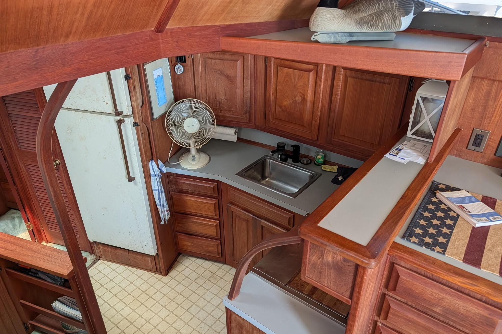1986 Viking Sportfish 41 yacht interior with wooden cabinetry, kitchenette, and vintage decor.