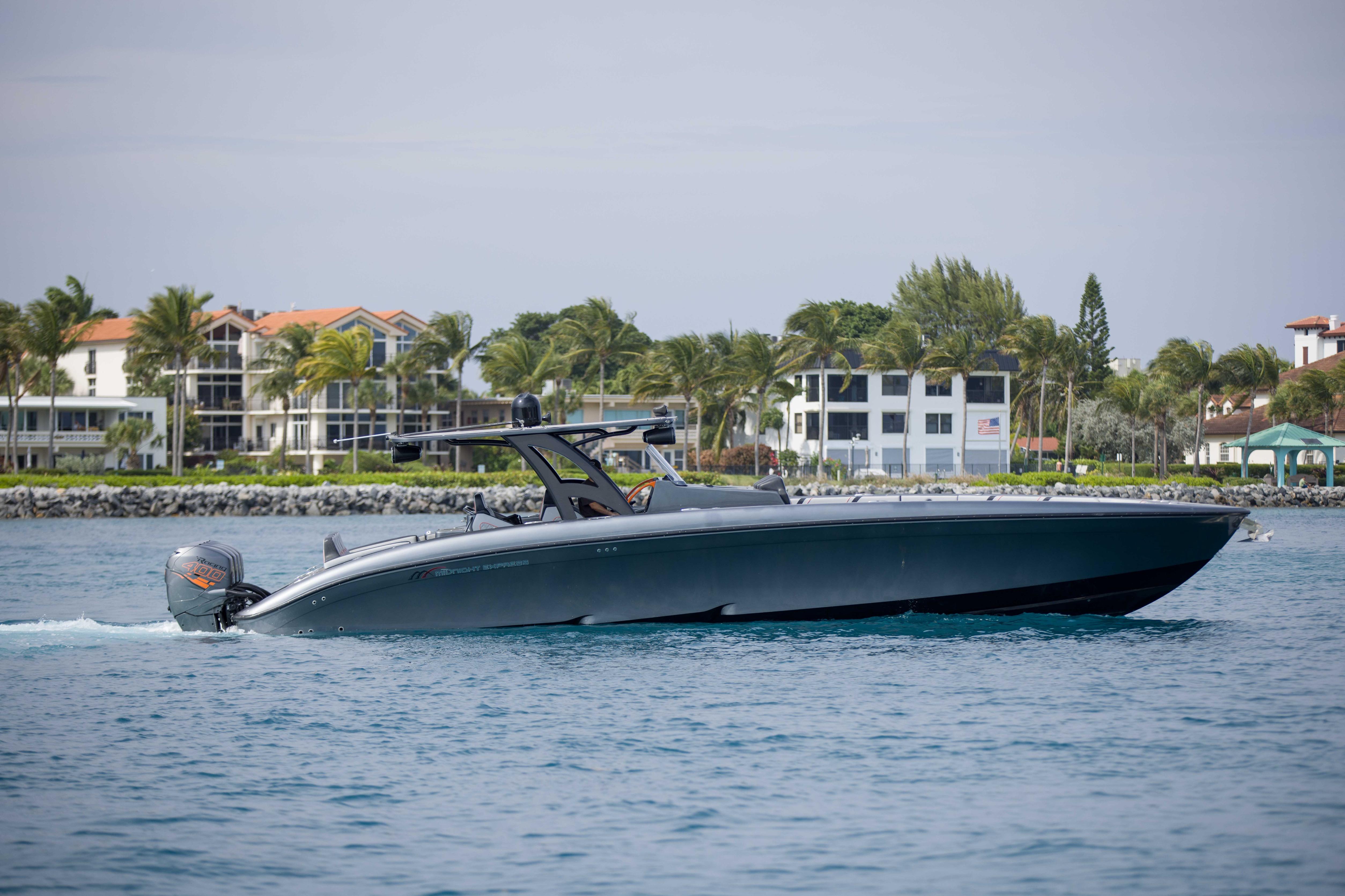 2019 Midnight Express 43 Open boat cruising near coastal homes and palm trees.