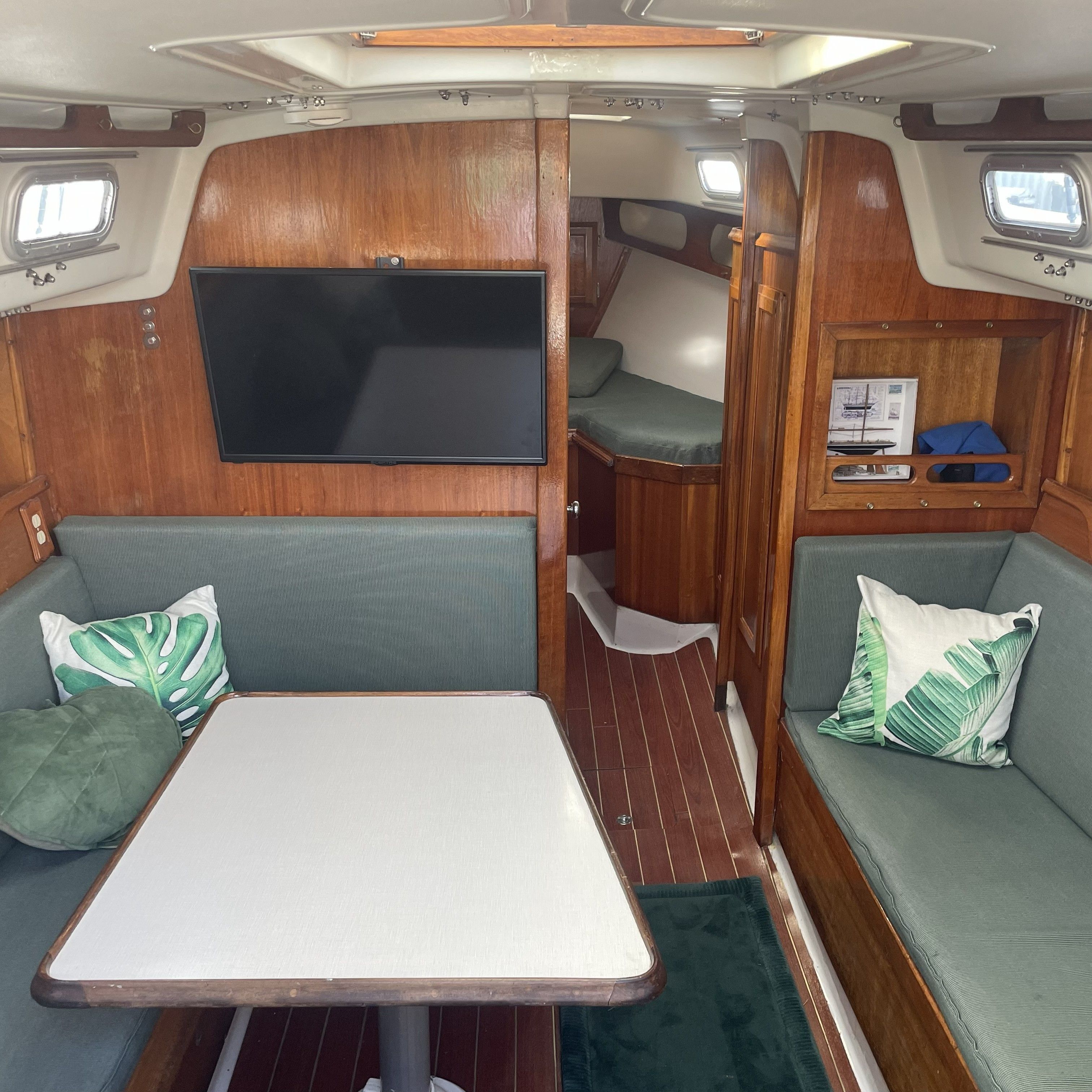 Interior of a 1974 Ericson 35 with wood paneling and green cushions.