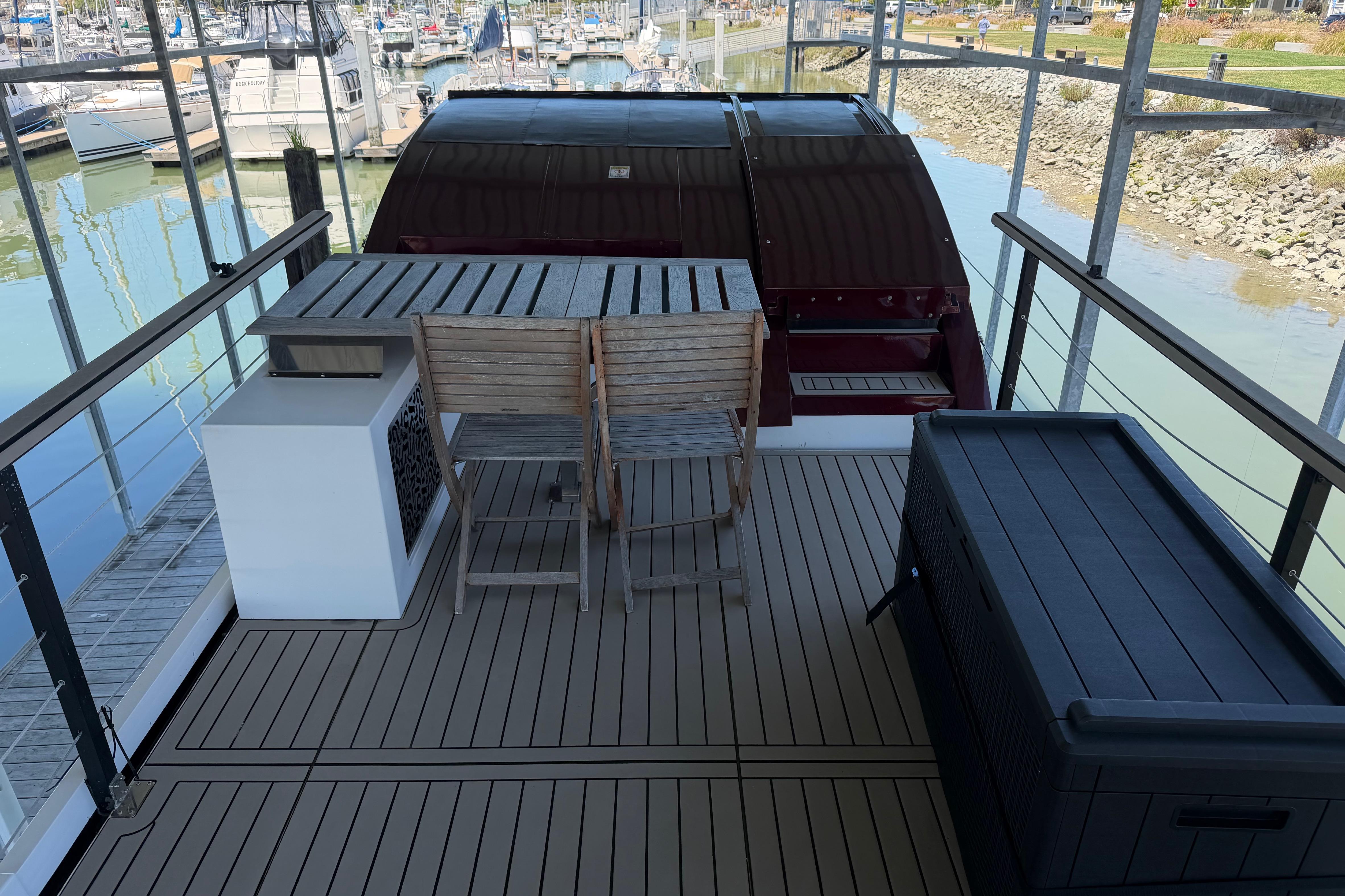 Navisyo NV.08 2022 yacht deck with wooden furniture and marina view.