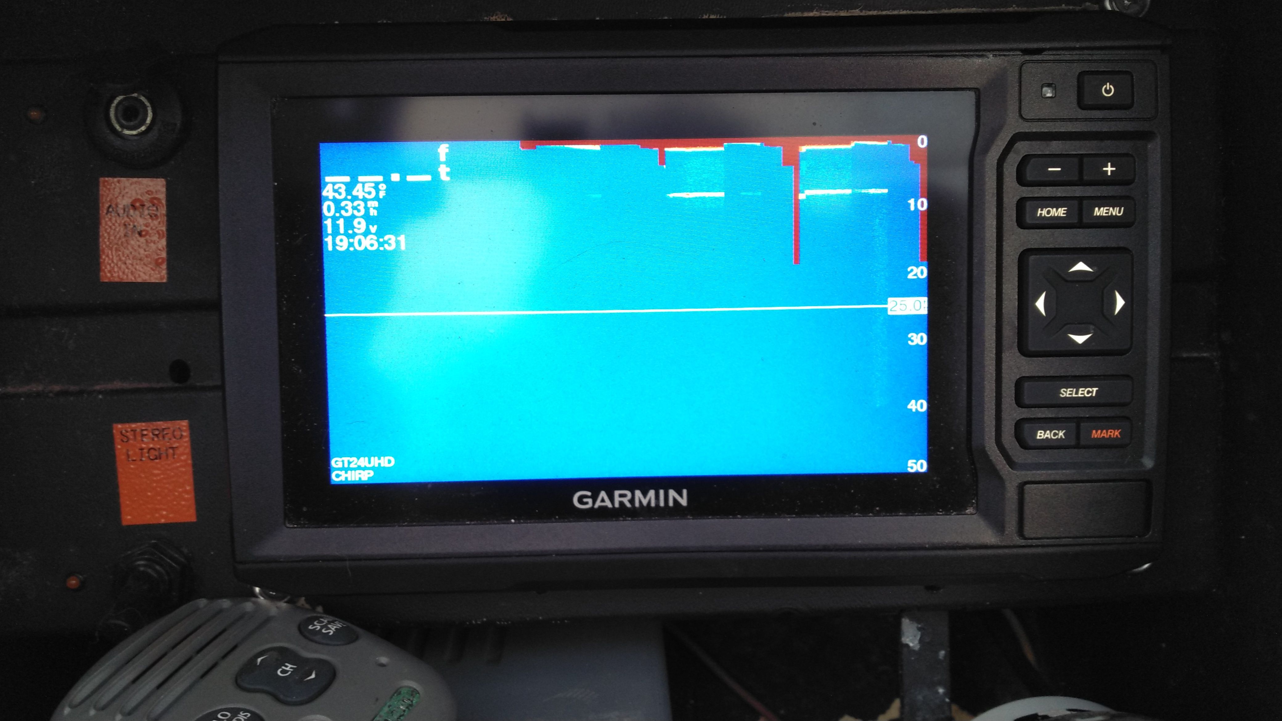 A Garmin fish finder on a boat displays depth information.