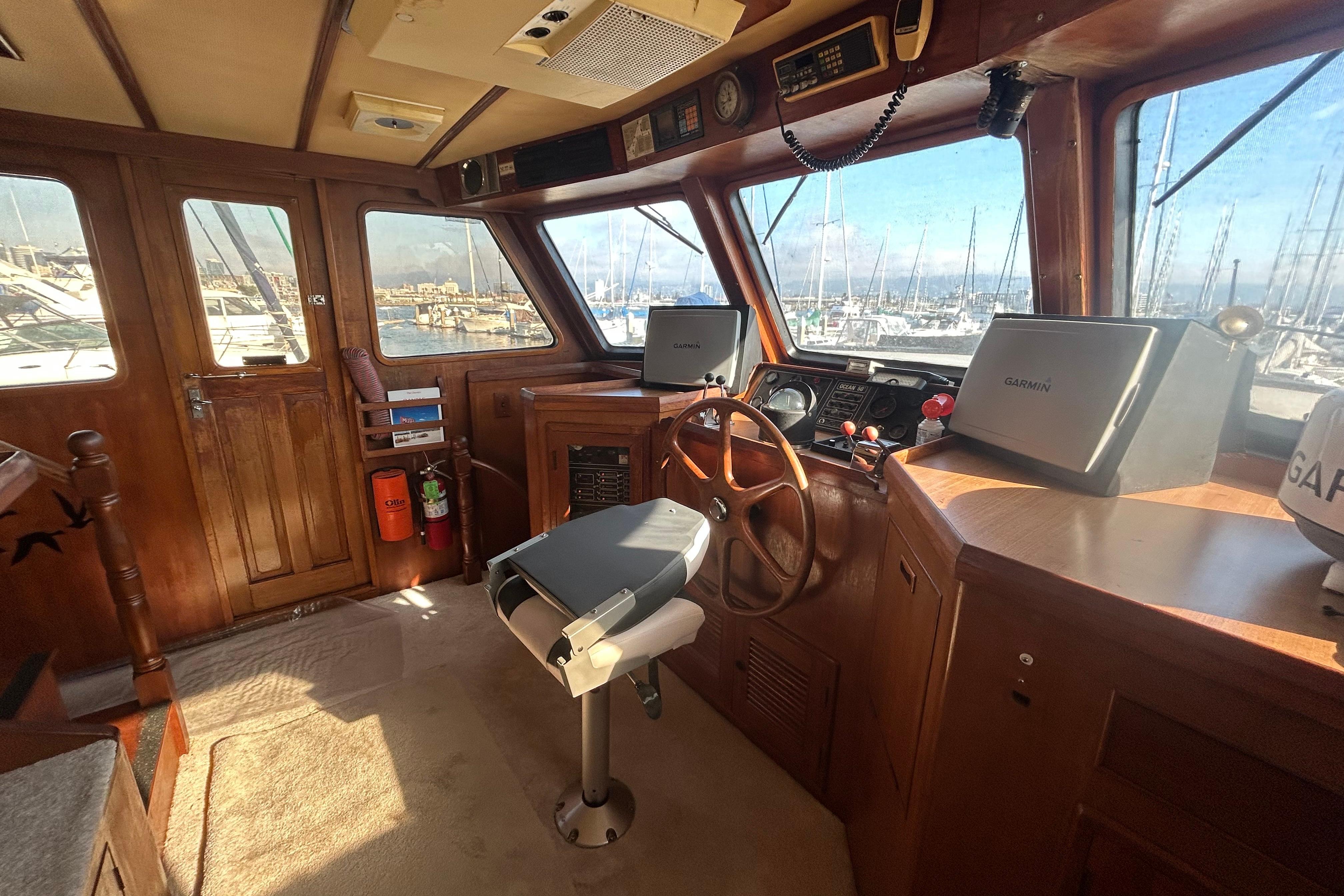 Interior of 1981 Ocean Alexander 50 Pilothouse with wooden helm and navigation equipment.