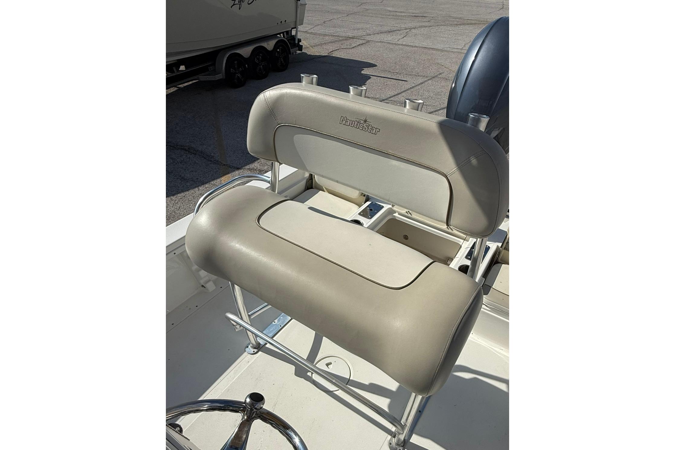 2015 NauticStar 224 XTS boat seat with rod holders, beige upholstery.