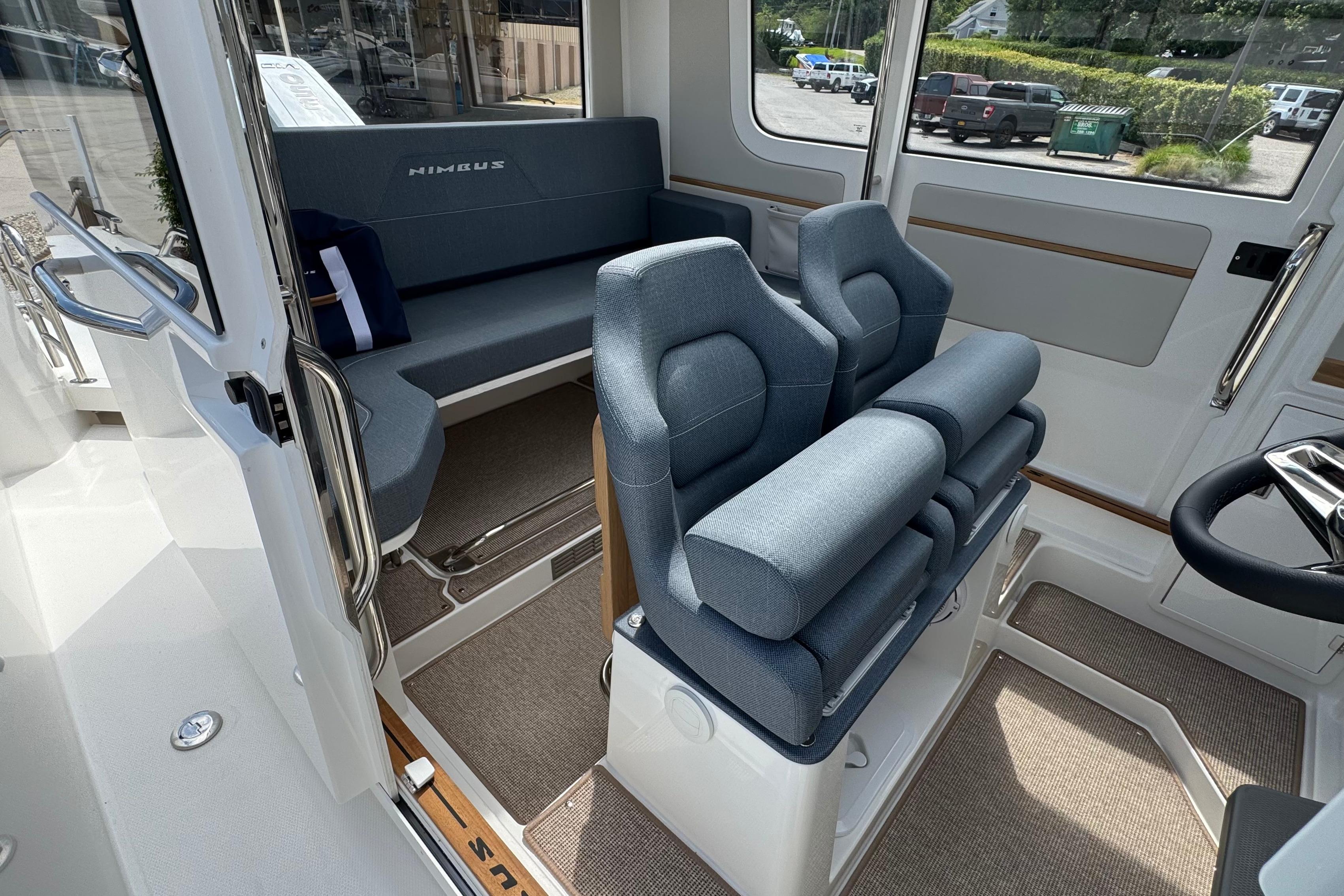 Interior of the Nimbus Commuter 9 with blue seating and large windows.