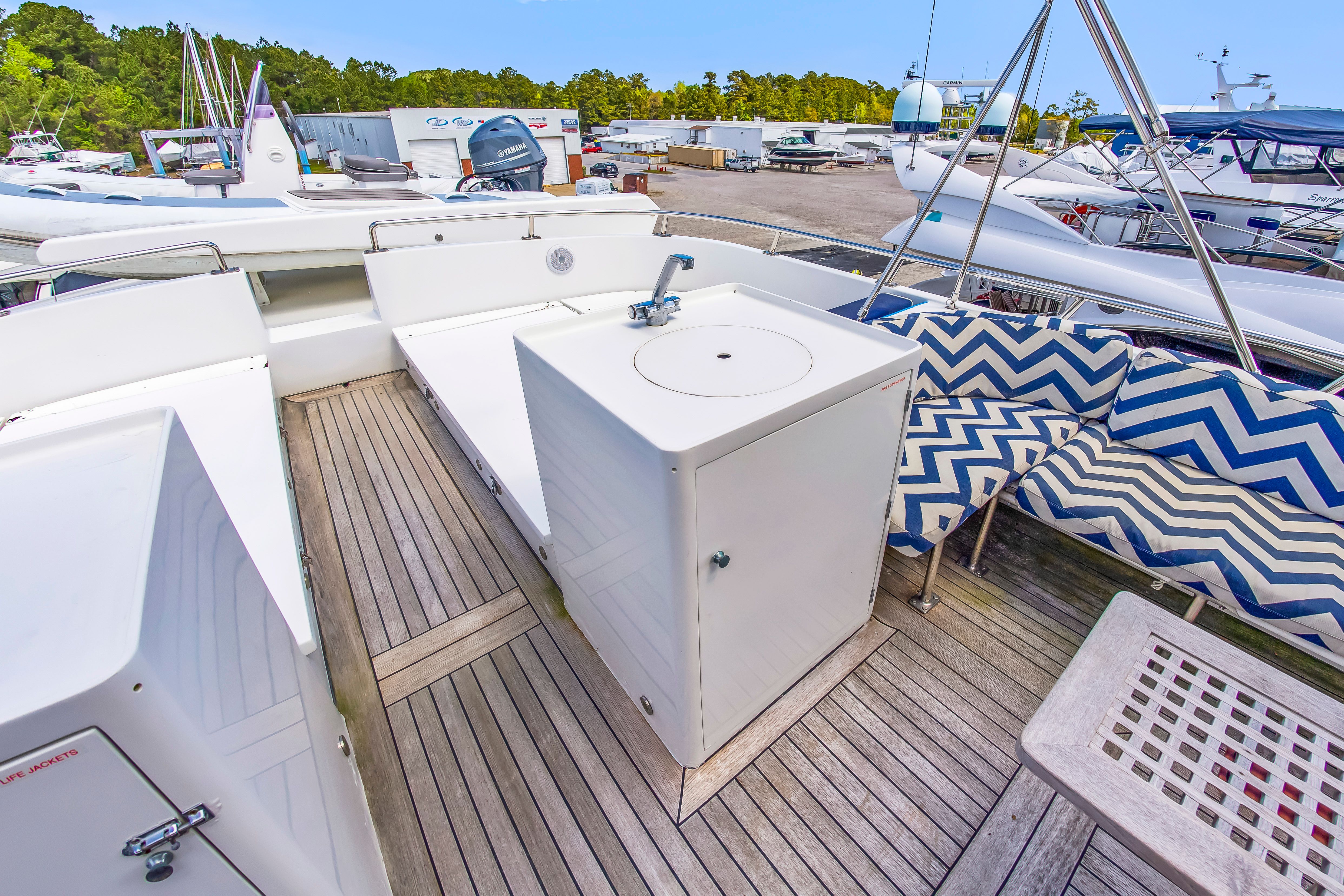 The image shows the deck of a 1987 Jongert 78 Motor Yacht with seating area and sink.