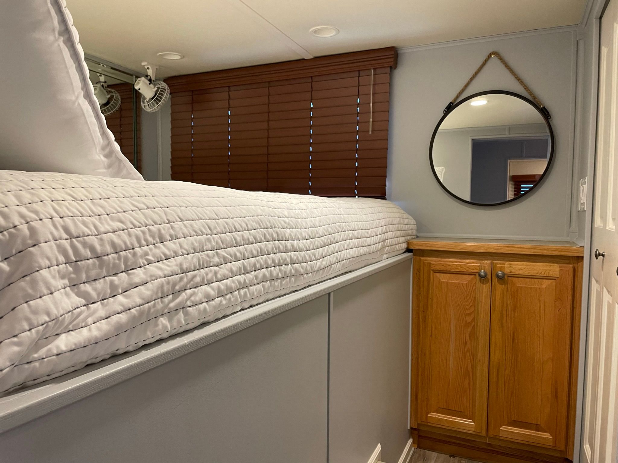 Interior of a 2001 Sumerset houseboat with bed and wooden cabinet.