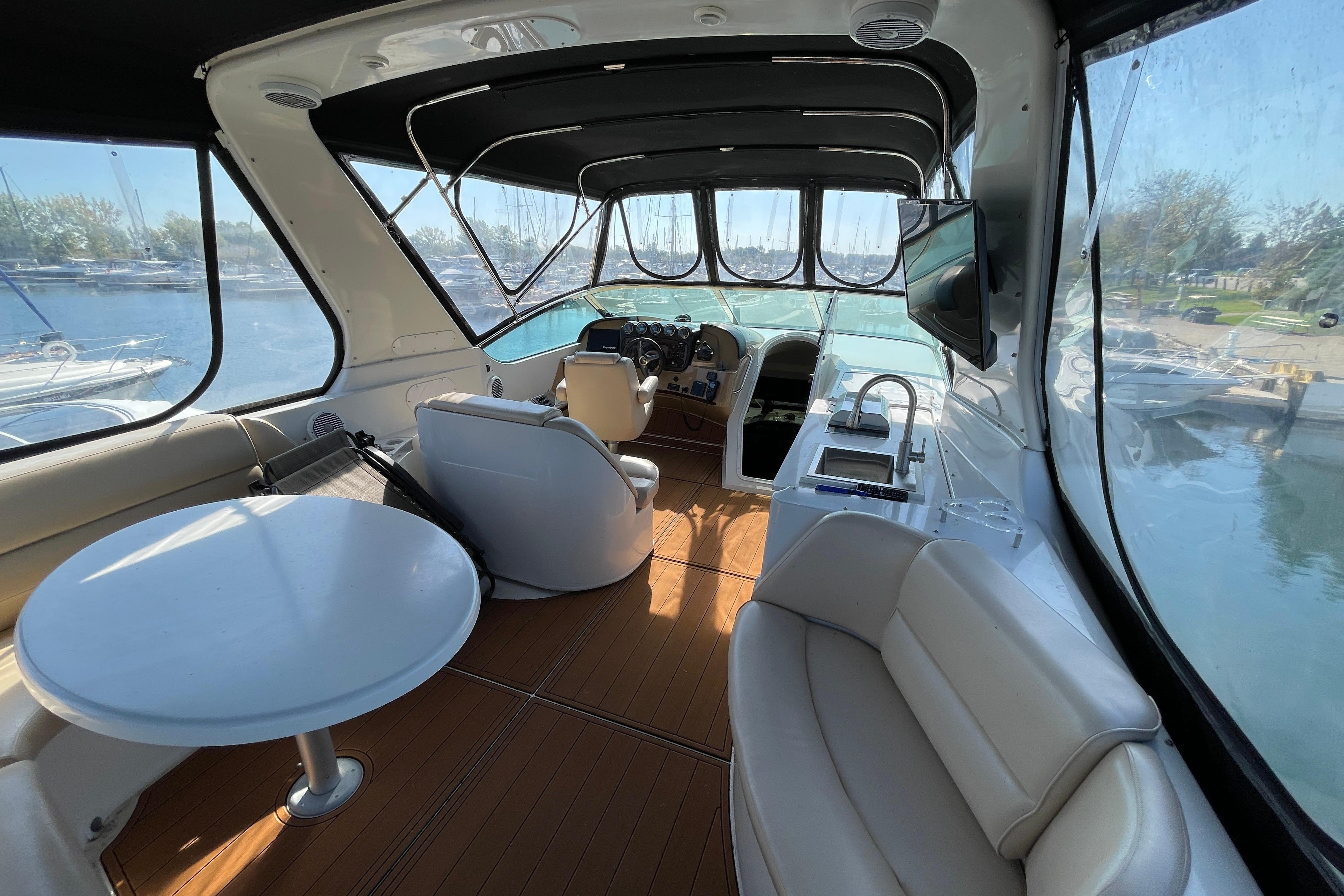 Luxurious 2002 Carver 570 Voyager Pilothouse interior with seating, table, and helm view.