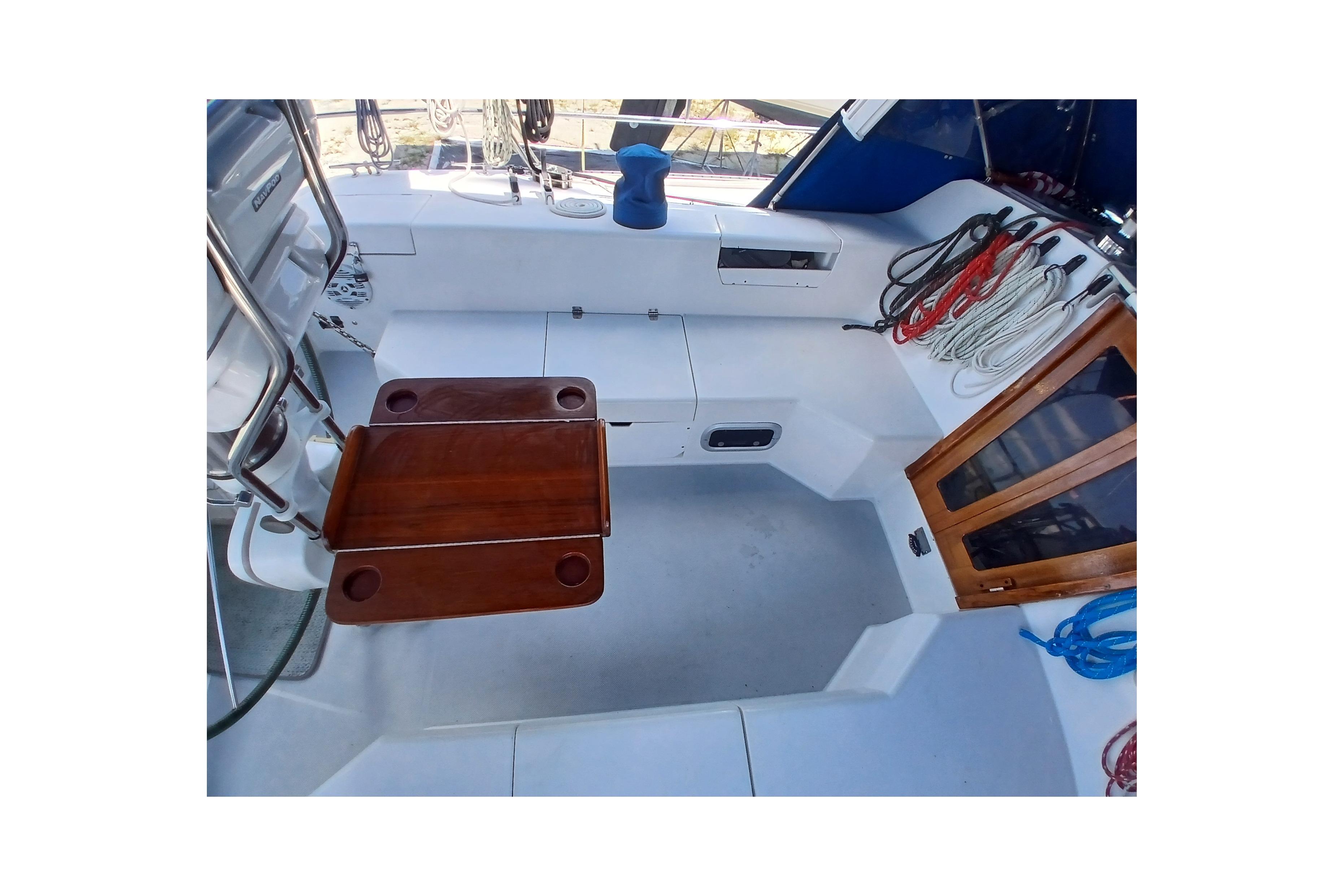 Cockpit of 1995 Catalina 42 MkII sailboat with wooden table and organized ropes.