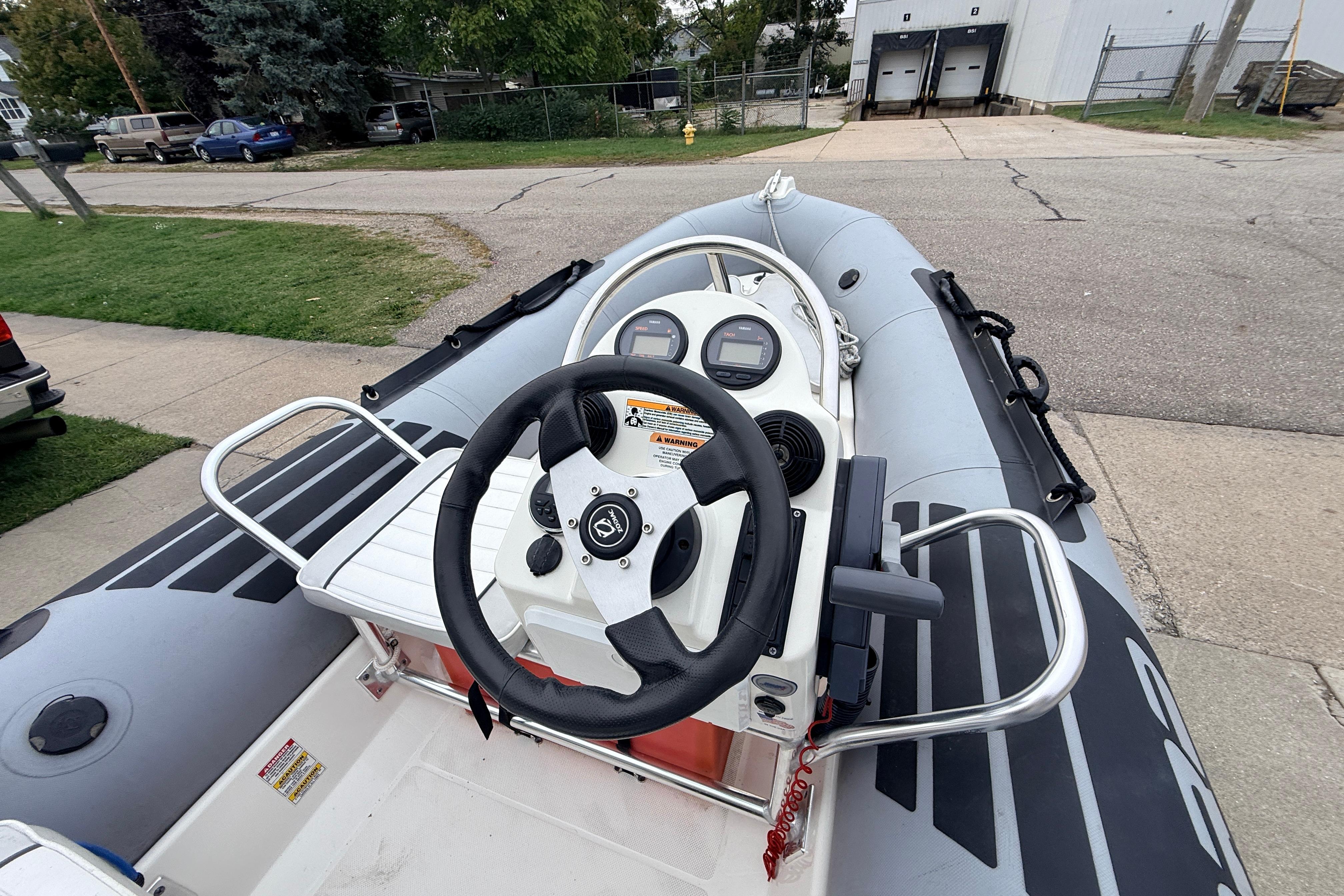 2014 Zodiac Pro Classic 420 inflatable boat with steering console, parked on a street.