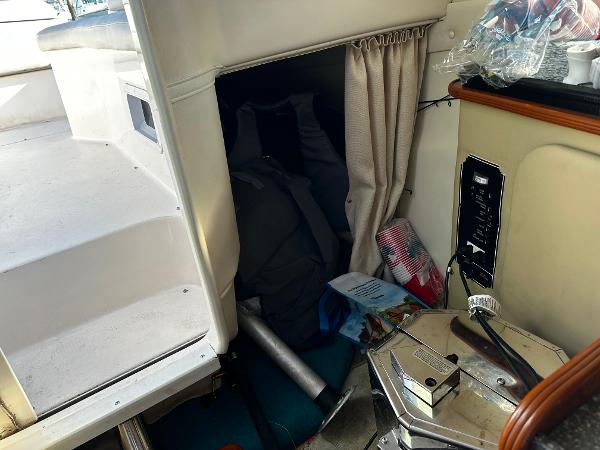 2004 Rinker Fiesta Vee 250 cabin interior with storage area and boating equipment.