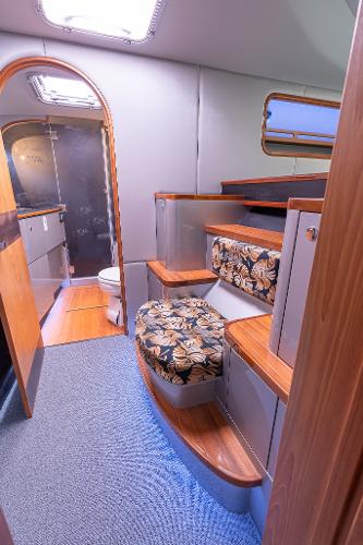 Interior of 2025 Shuttleworth 52 AeroRig yacht, featuring wooden steps and floral-patterned seating.