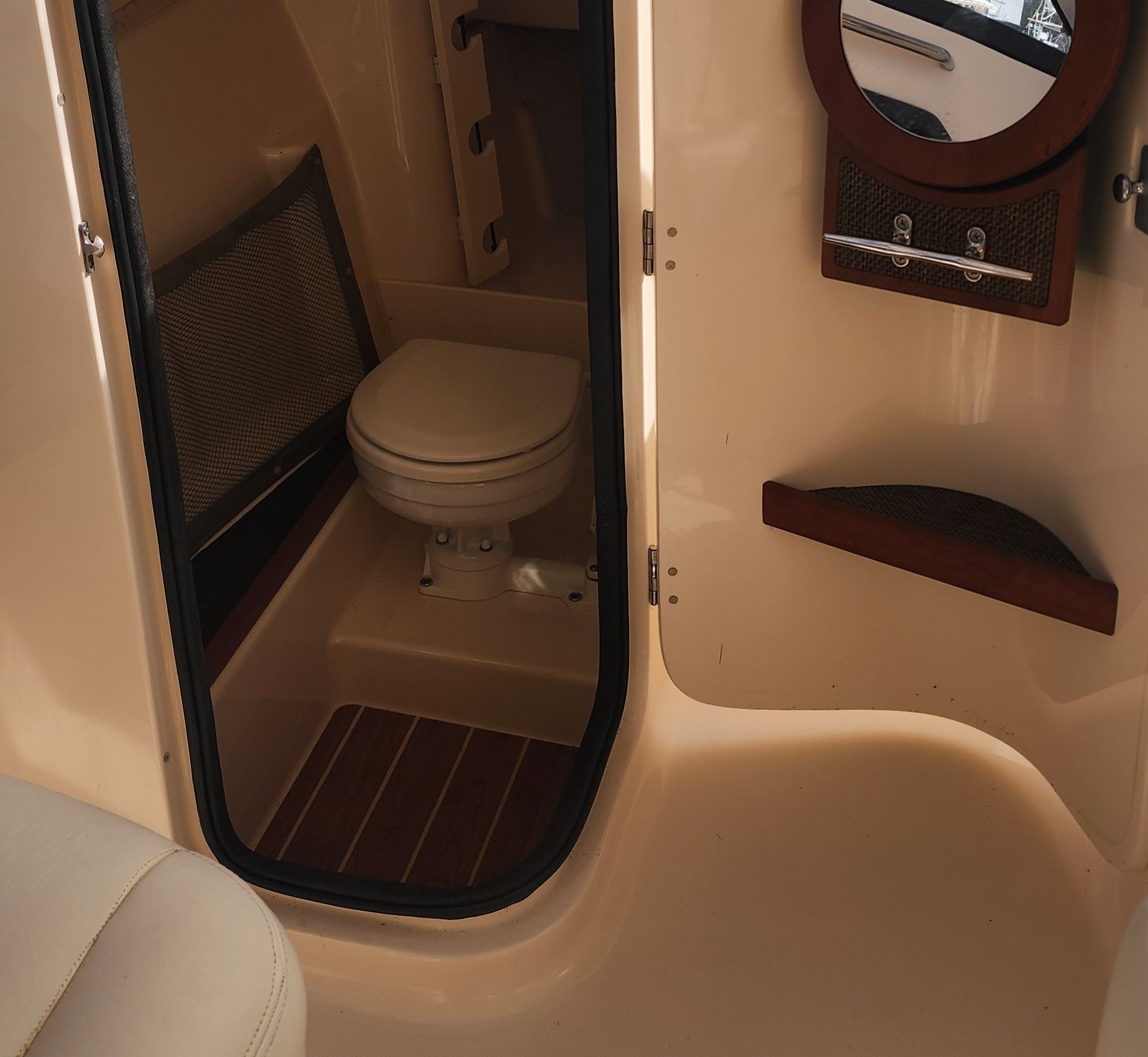 The image shows the interior of a 2015 Grady-White Freedom 275 with a toilet and mirror.