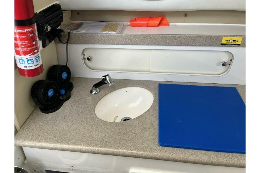 Interior of a 2006 Century 2400 Walk-Around boat with sink and countertop.