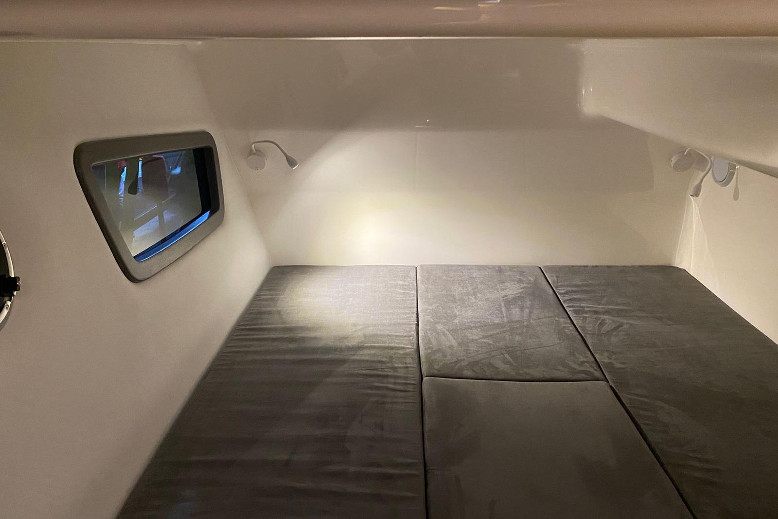 Interior cabin of 2026 Hanover 375 with cushioned bed and window view.
