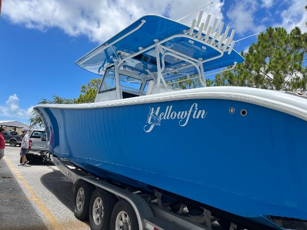 2022 Yellowfin 39 Offshore boat on trailer, vibrant blue hull, clear sky background.