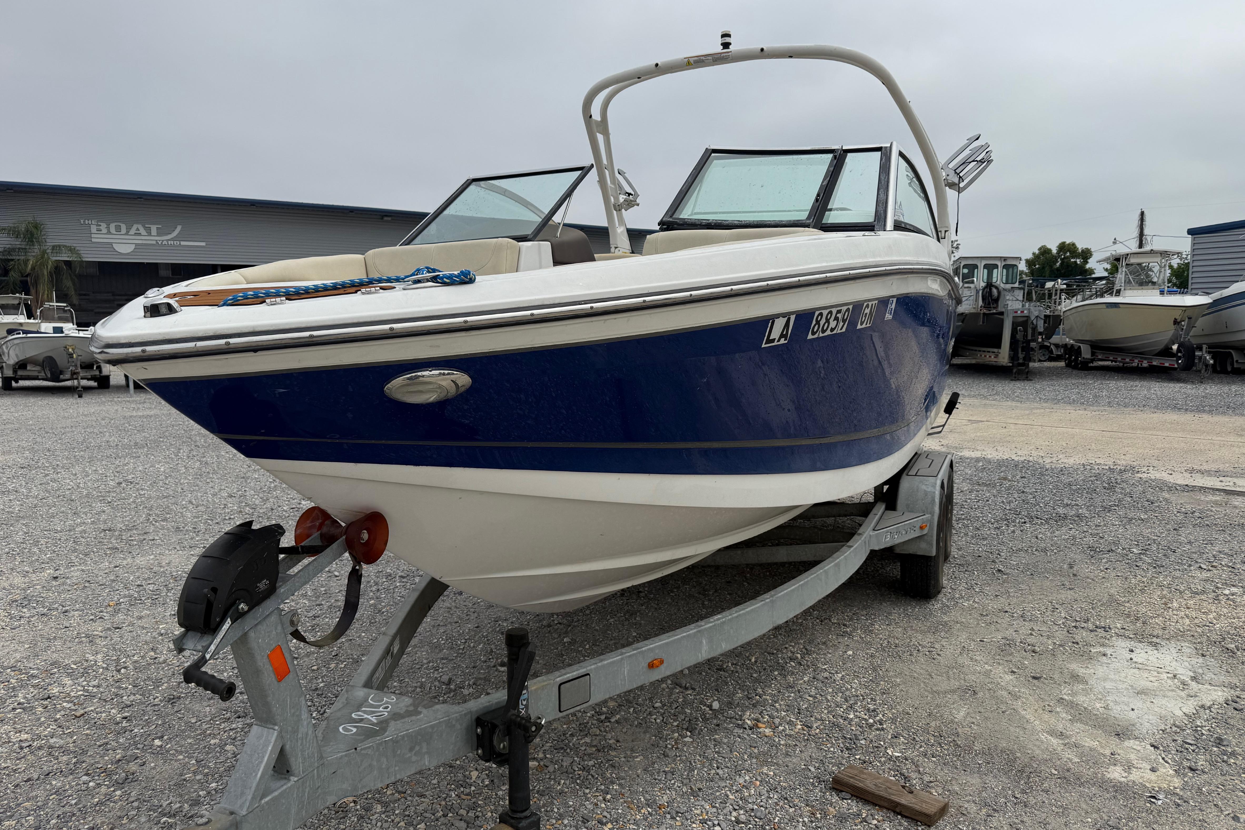 2018 Bryant Calandra boat on trailer in a gravel lot, overcast sky.