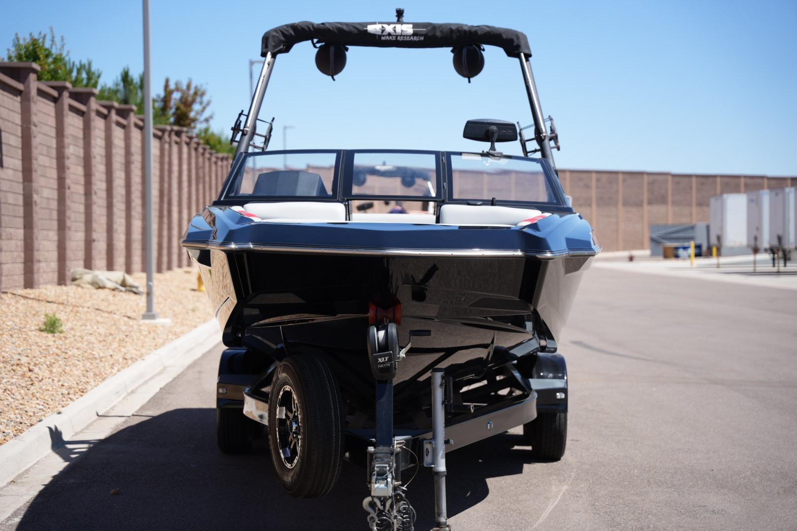 2019 Axis A22 boat on trailer, parked on a sunny street.