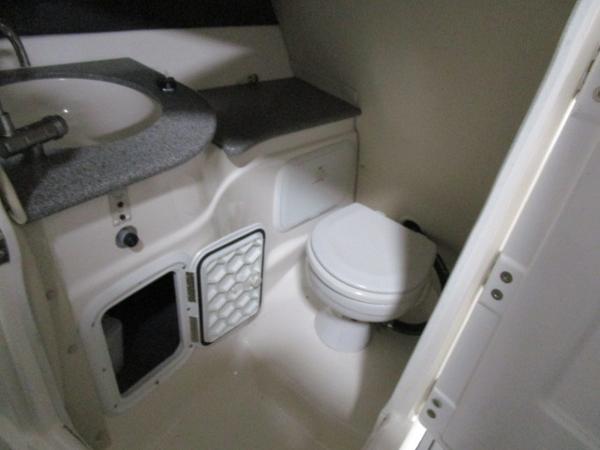 Compact bathroom in 2017 Larson 292 LXI boat with sink and toilet.