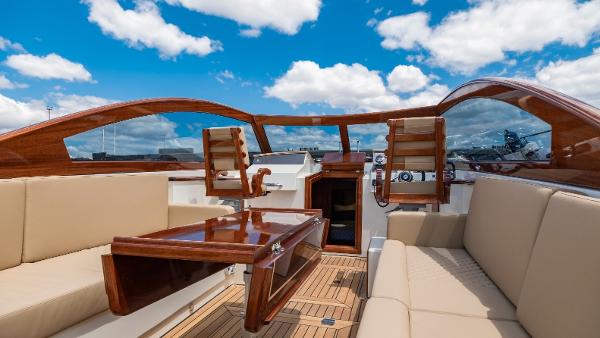 2023 Vento V40 Retro Classic Open boat interior with wooden accents and beige seating under blue sky.