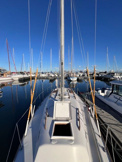 A 1969 Morgan 30 sailboat docked in a marina, surrounded by other boats under a clear sky.
