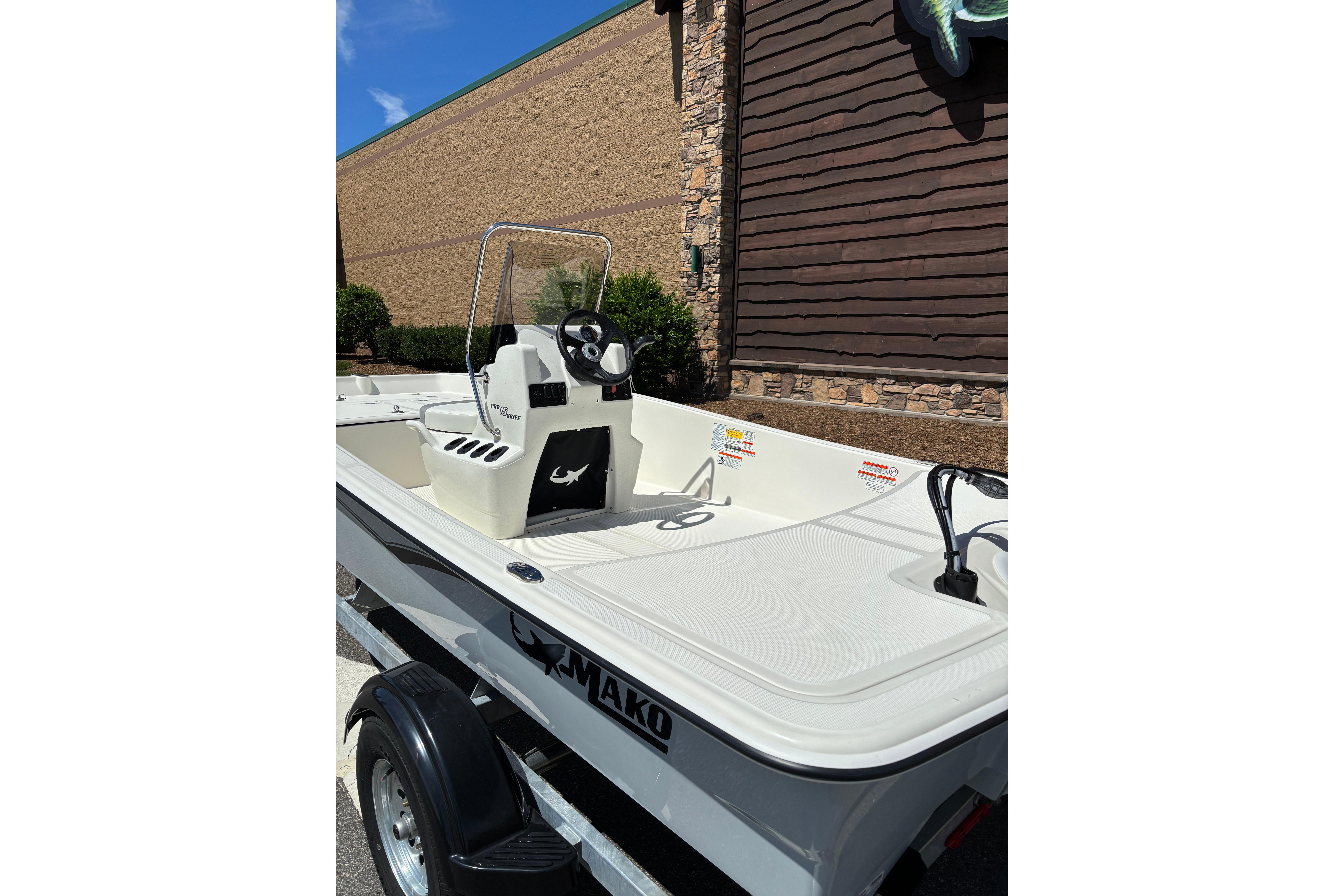2026 Mako Pro Skiff 15 CC boat on trailer, parked outdoors.