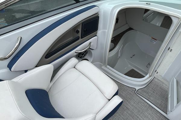 2023 Crownline E235 boat interior with white and blue seating and open cabin door.