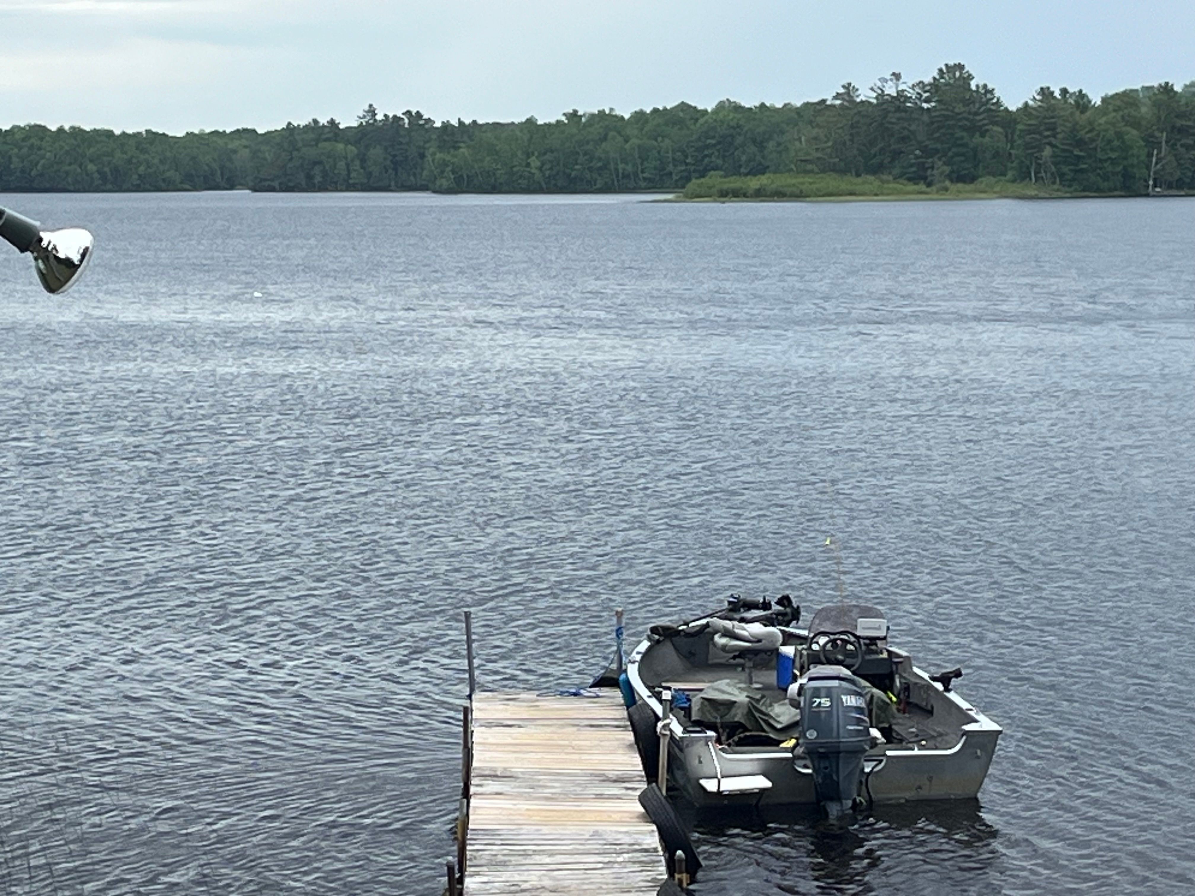 A 2005 Alumacraft Navigator 175CS is docked at a wooden pier on a calm lake.