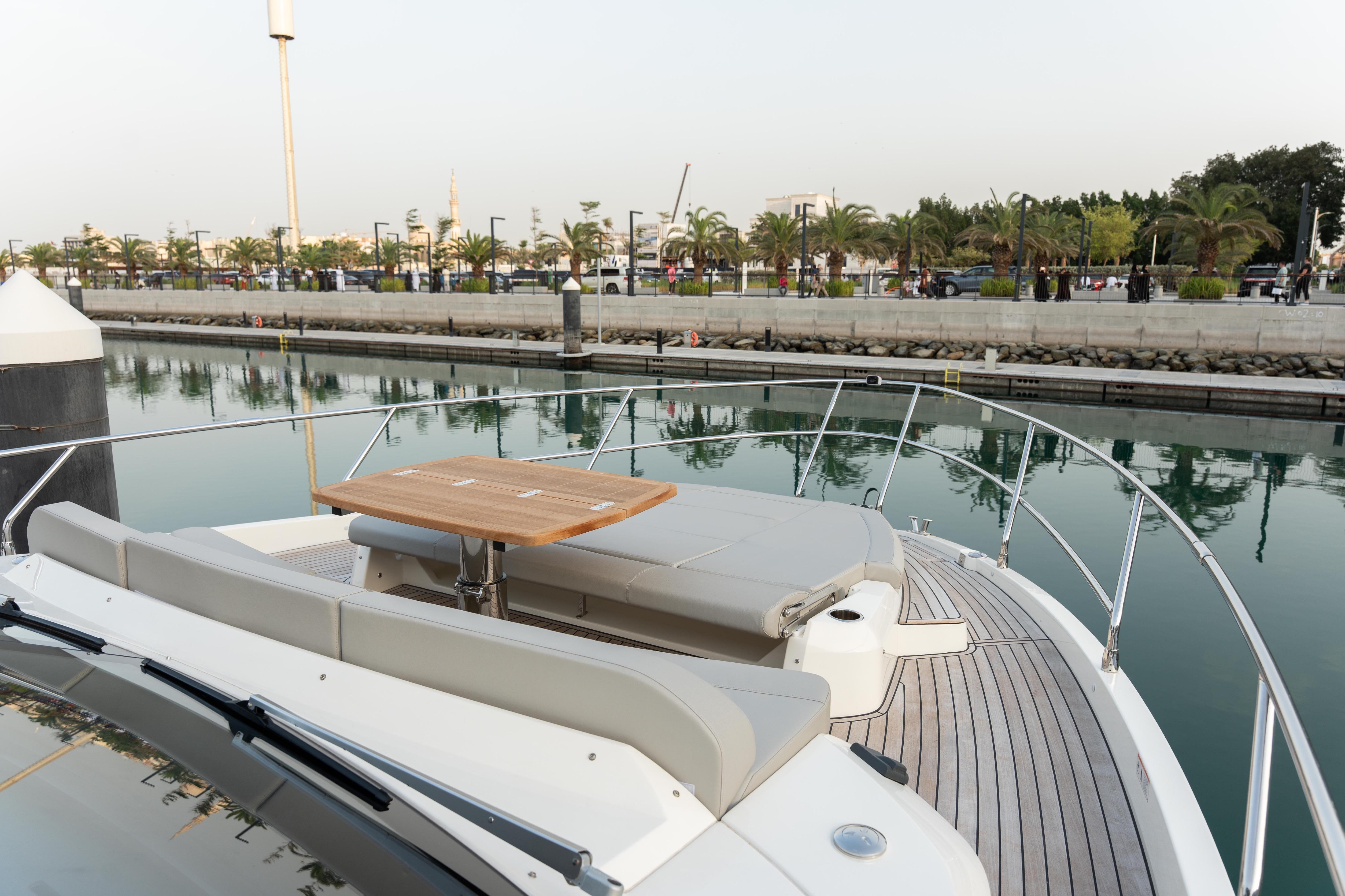 Luxury Absolute 52 FLY yacht docked, featuring elegant deck seating and table, 2025 model.