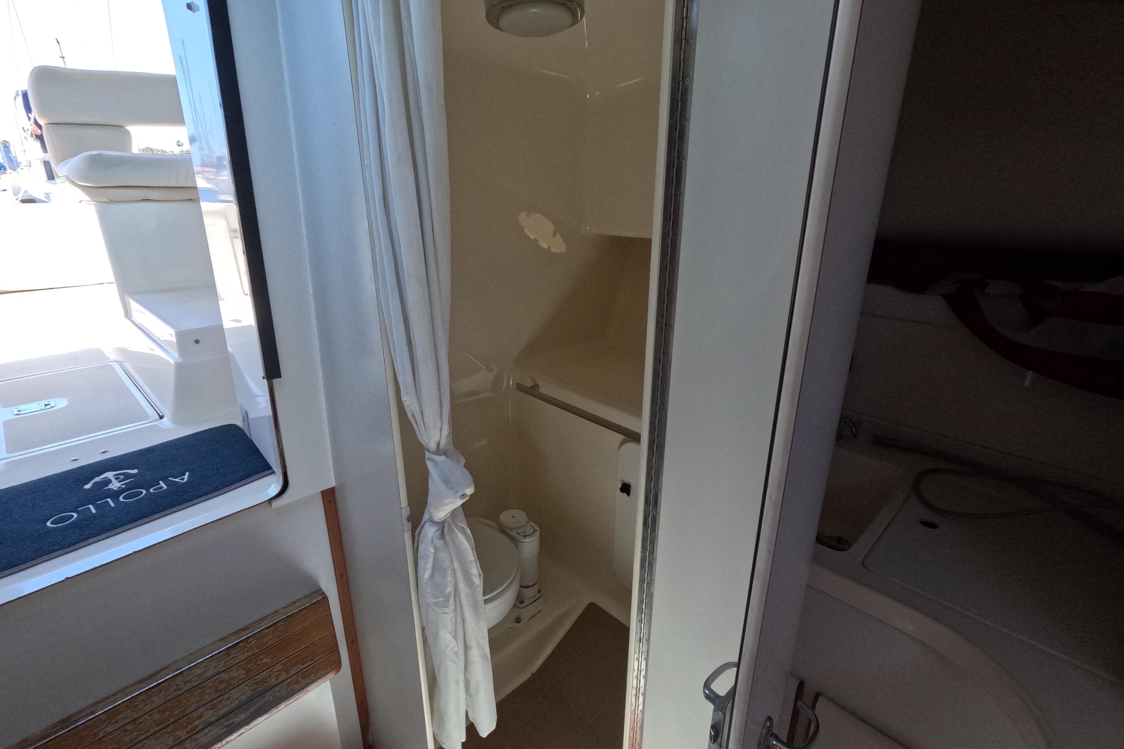 1995 Tiara Yachts 2900 Open interior with compact bathroom and seating area.